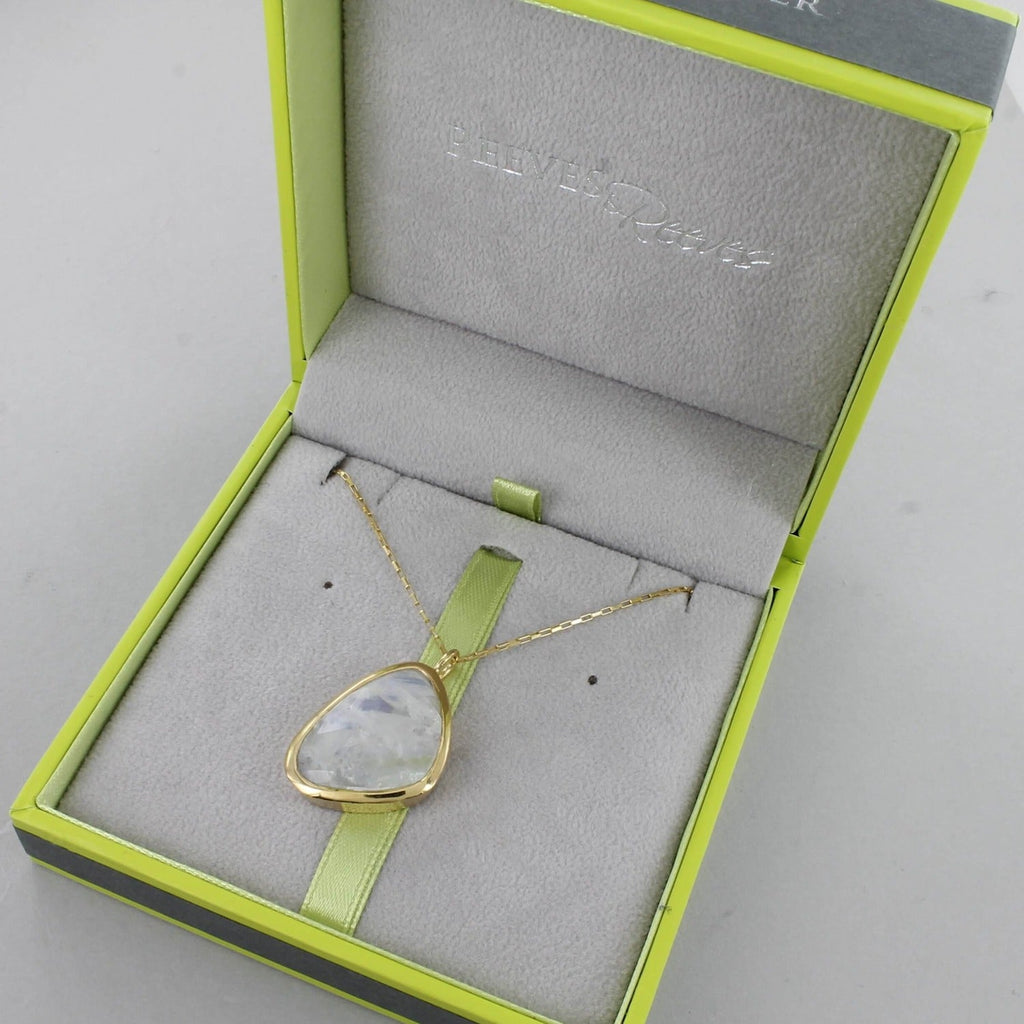 A rainbow moonstone, set in gold plating and on a gold box chain. Shown in a Reeves & Reeves grey and green branded gift box.