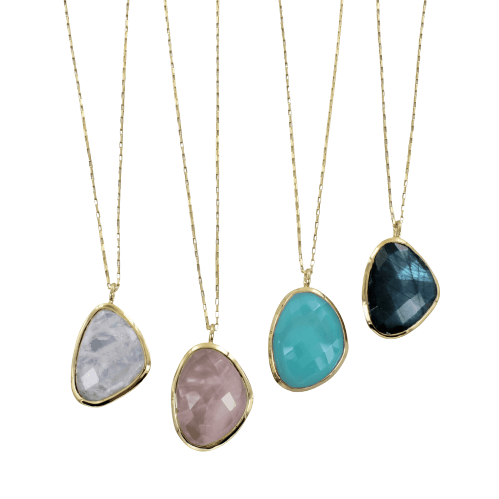 A collection of four gold-plated necklaces with different coloured stones (rainbow moonstone, labradorite, aqua chalcedony, and rose quartz) set in gold vermeil with a box link chain. 