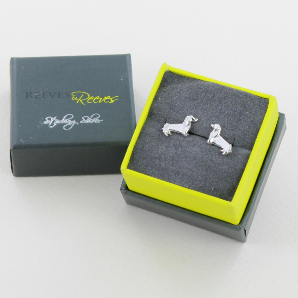 A pair of sterling silver Dachshund Stud Earrings in an origami design and shown in a Reeves & Reeves gift box.