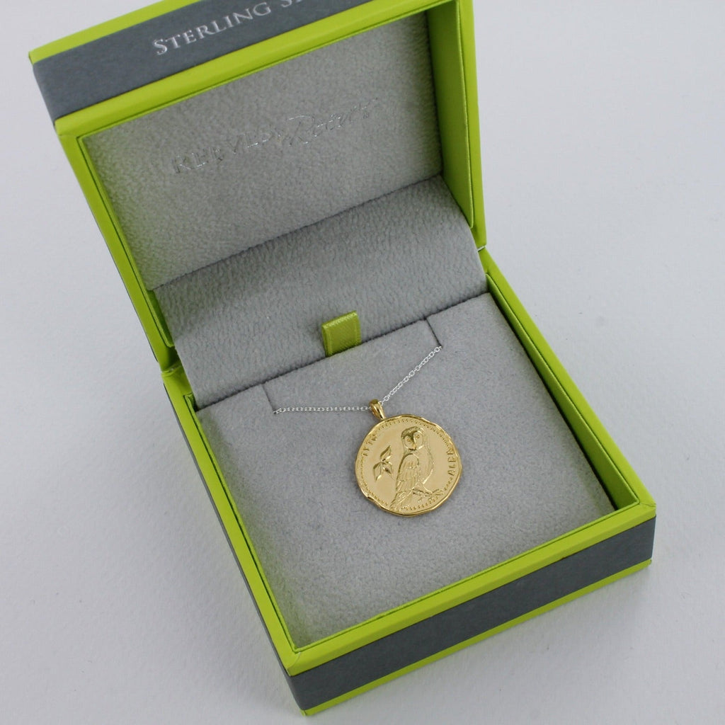 Gold plated owl coin necklace on a chain, shown in a Reeves & Reeves grey and green branded gift box.