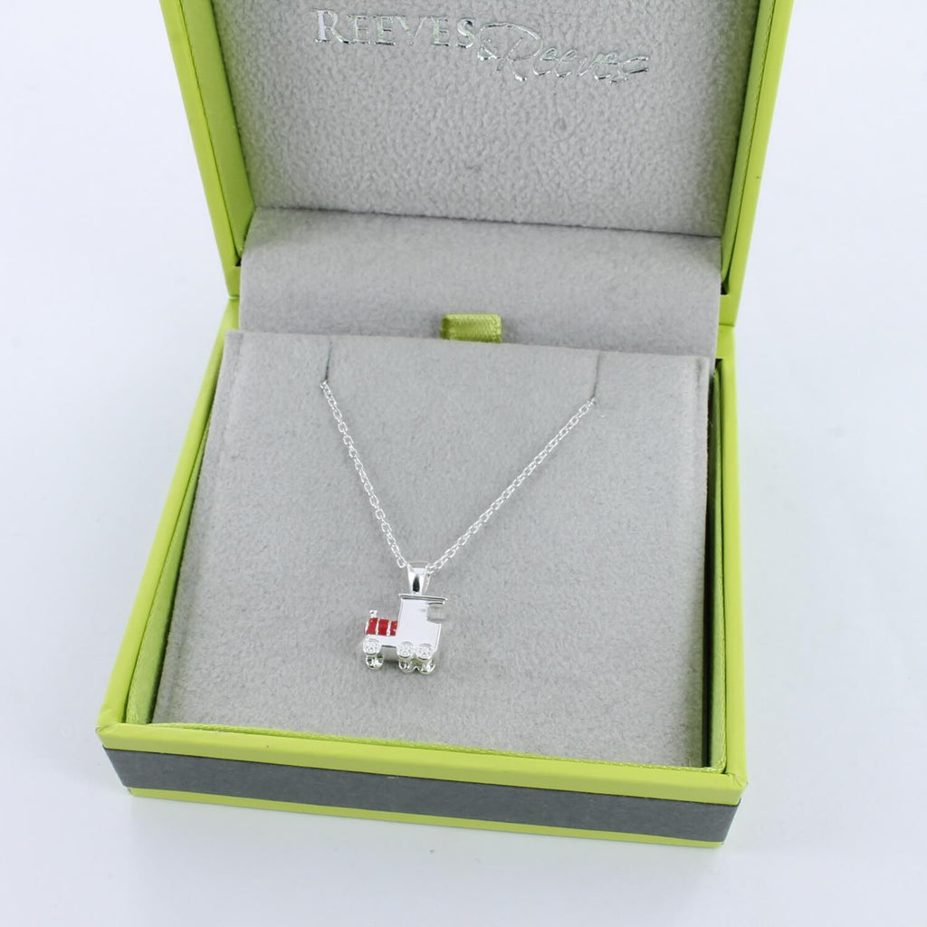 A sterling silver train necklace with red enamel detail, hung on a silver adjustable chain and shown in a Reeves & Reeves grey and green gift box.