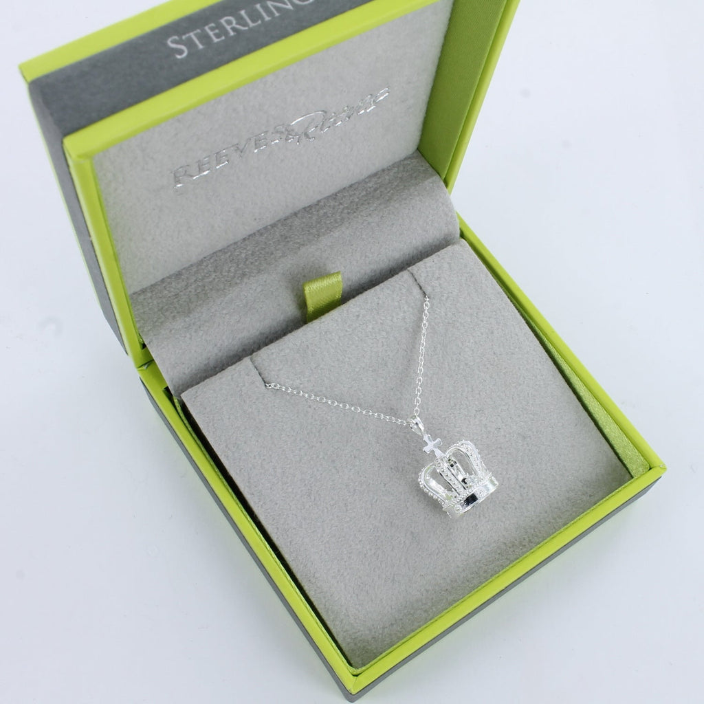 A sterling silver regal crown necklace with intricate details, shown on an adjustable chain and in a Reeves & Reeves gift box.