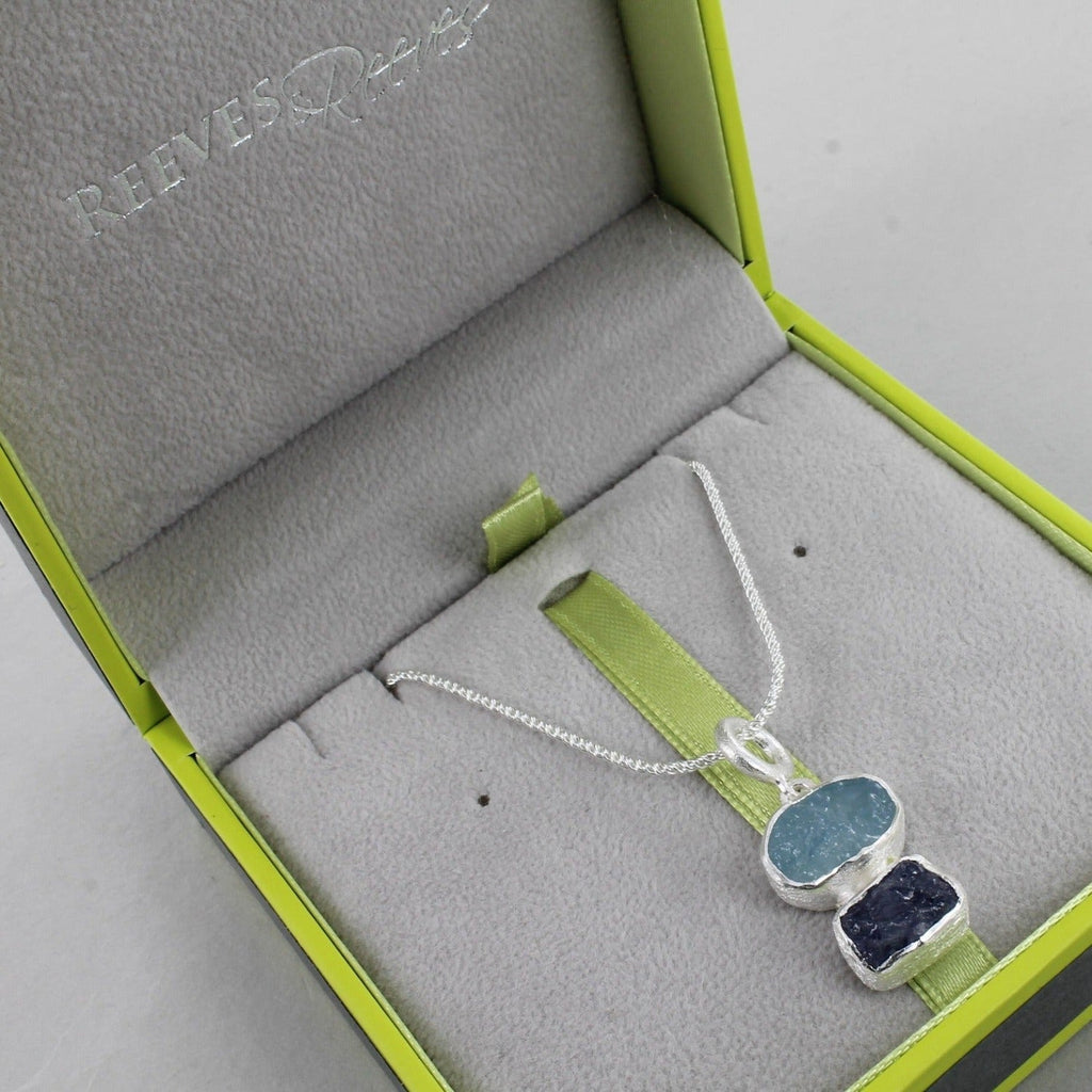An aqua and tanzanite semi-precious stone set in sterling silver and hung on a silver rope style chain in a Reeves & Reeves gift box.