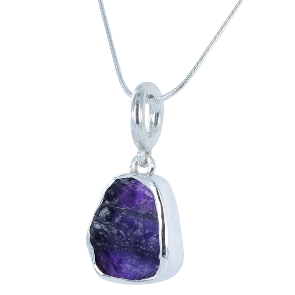 A rough cut tanzanite stone, set in sterling silver and hanging from a silver rope style chain.