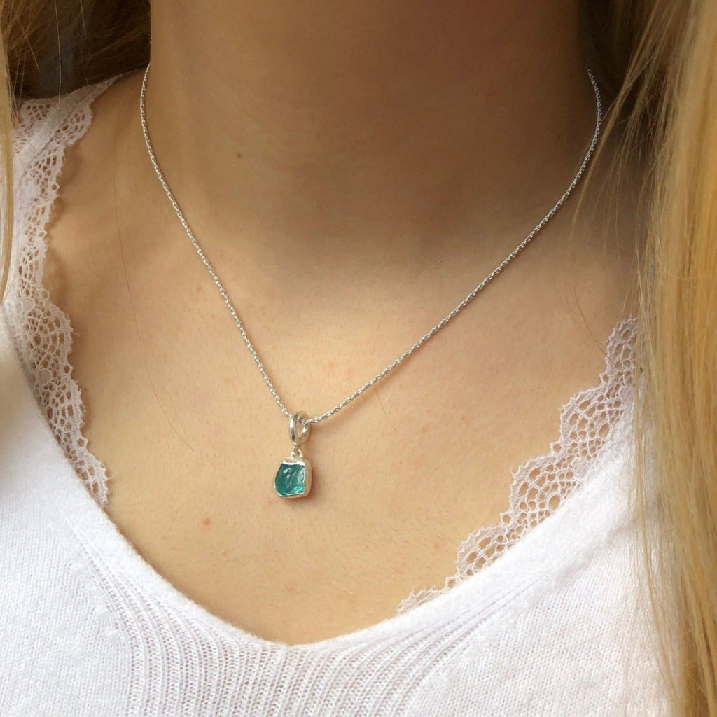 A rough cut appetite stone, set in sterling silver and hanging from a rope style chain. Worn on a model.