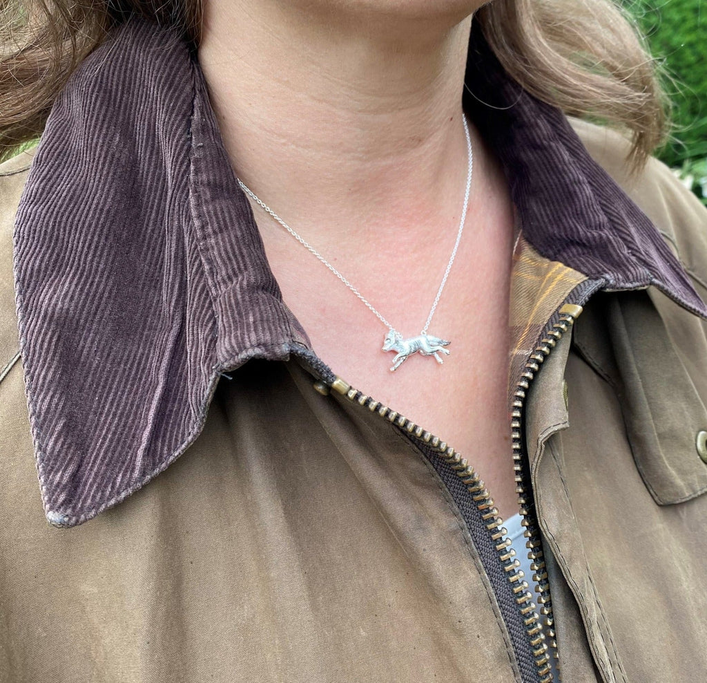 Silver Running Fox Pendant on a silver adjustable chain, worn on a models neck.