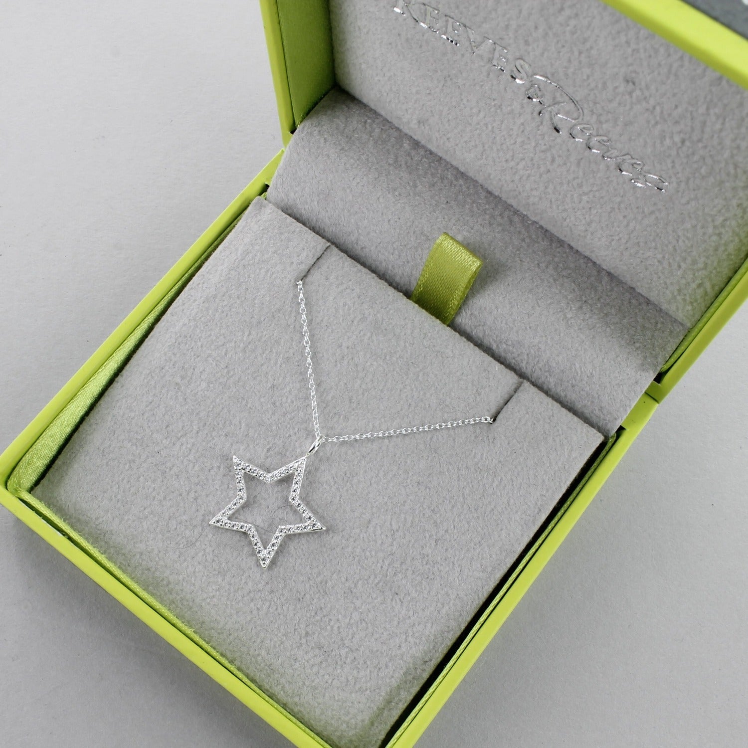 A Silver Star Silhouette Necklace, shown in a Reeves & Reeves grey and green branded box.
