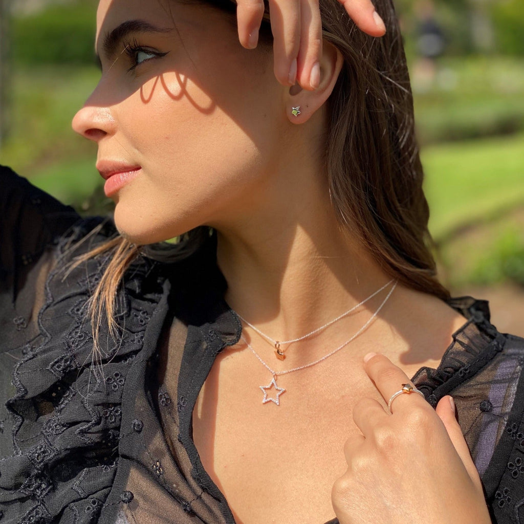 A Star silhouette necklace, filled with cubic zirconia stones and worn on a model.