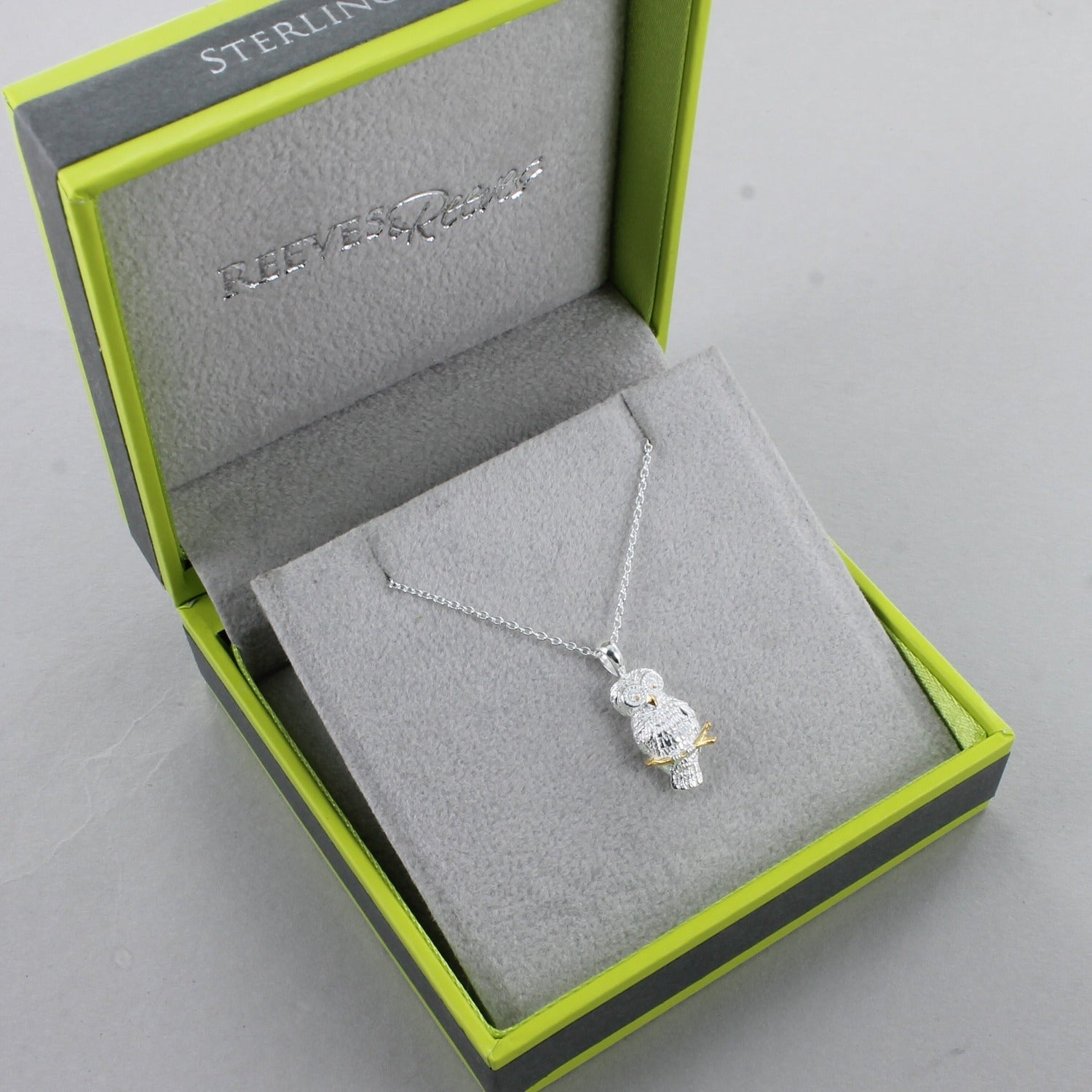 Sterling Silver and gold plate owl necklace on a silver chain, shown in a Reeves & Reeves grey and green branded gift box.