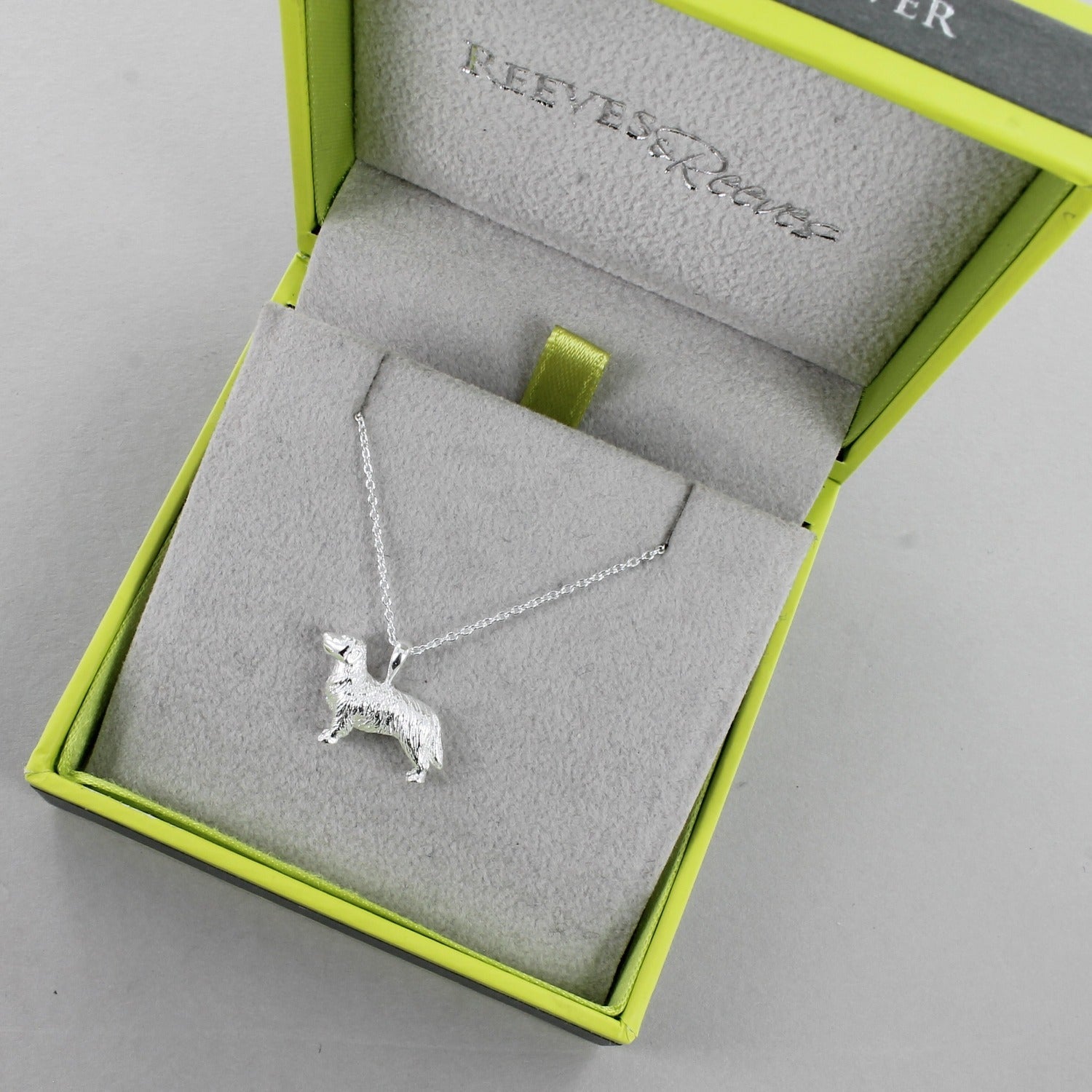 A Sterling Silver Retriever Necklace, hung on a silver chain and shown in a Reeves & Reeves gift box.