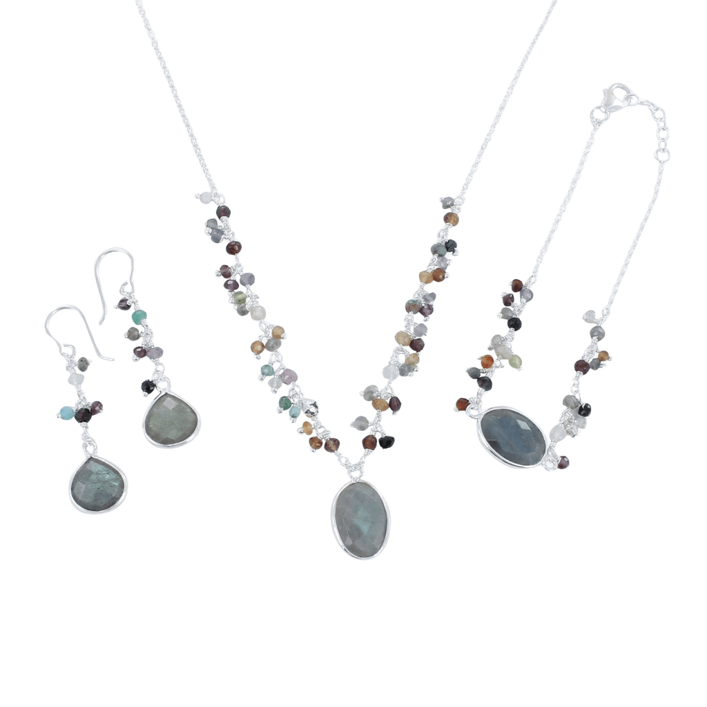 A sterling silver chain necklace with an oval labradorite stone at the centre. Coloured stones sit up either side of the chain and the necklace is shown with the matching bracelet and drop earrings.