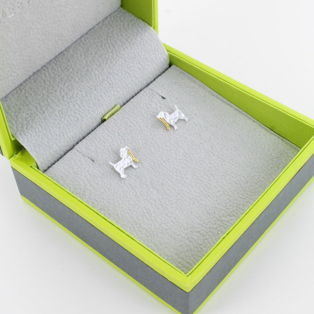 Sterling Silver Hammered Dog Studs with a gold plated lead held in the dogs mouth. Shown in a Reeves & Reeves grey and green branded gift box.