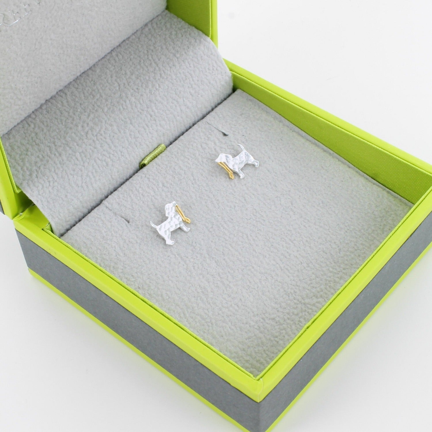 Sterling Silver Hammered Dog Studs with a gold plated lead held in the dogs mouth. Shown in a Reeves & Reeves grey and green branded gift box.