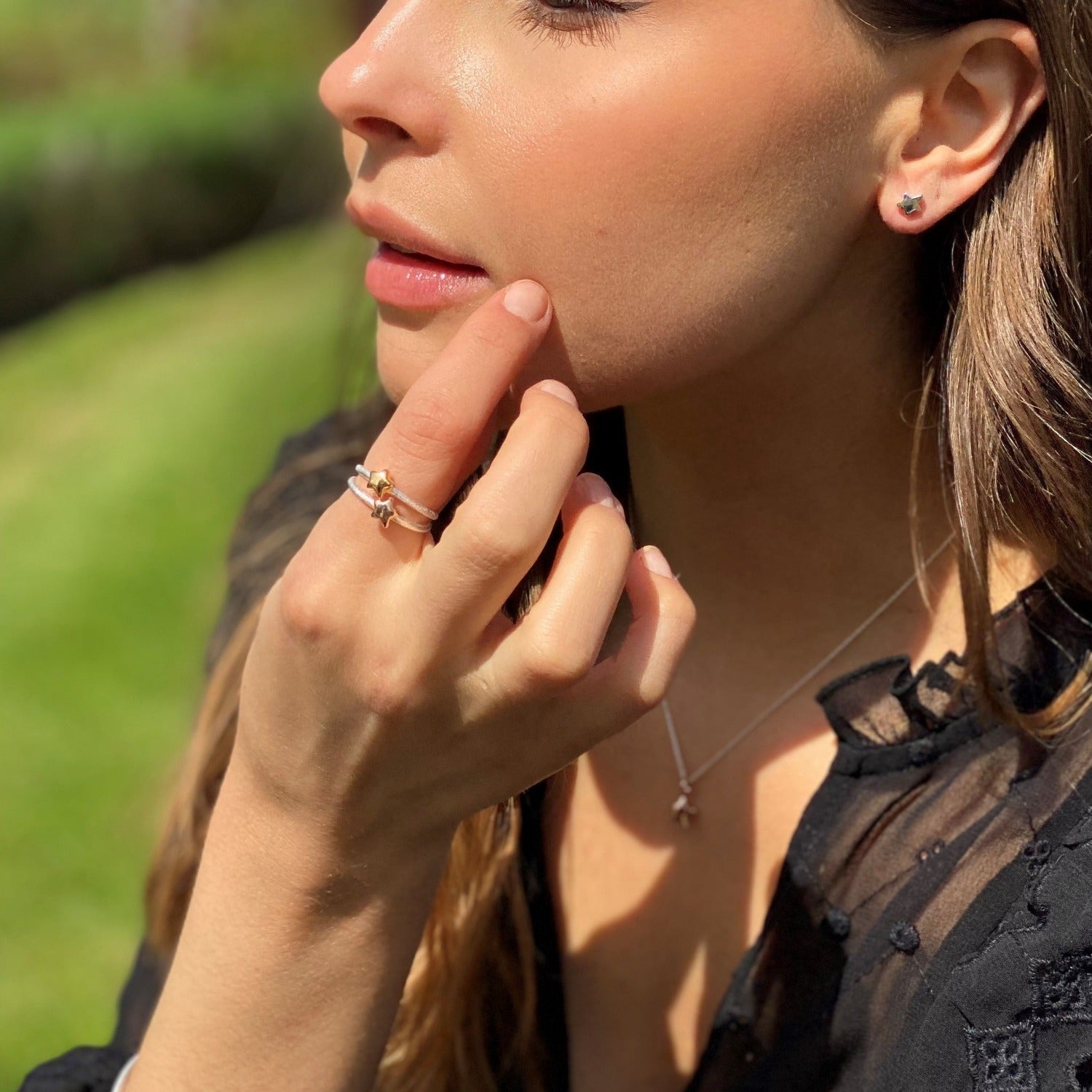 Two Starlight Rings stacked on top of each other, worn on a ladies finger with the matching stud earrings and necklace.