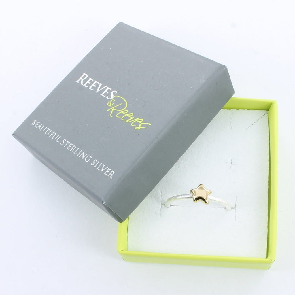 Silver Starlight Ring with a silver band and gold plated star, shown in a Reeves & Reeves grey and green branded gift box.