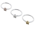 Three silver banded matt rings, one with a silver star, one with a yellow gold plated star and the other a rose gold plated star.