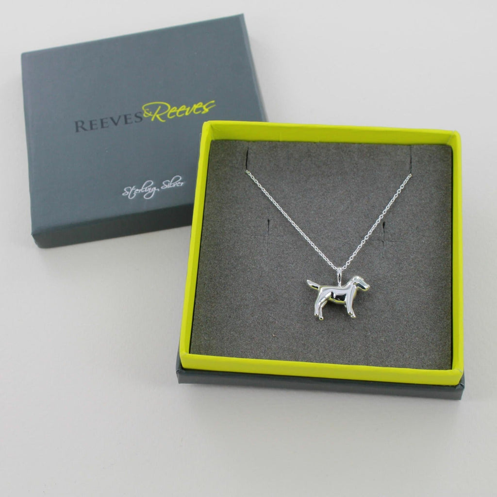 A Sterling Silver Dog Pendant worn on a silver chain and shown in a Reeves & Reeves grey and green branded gift box.