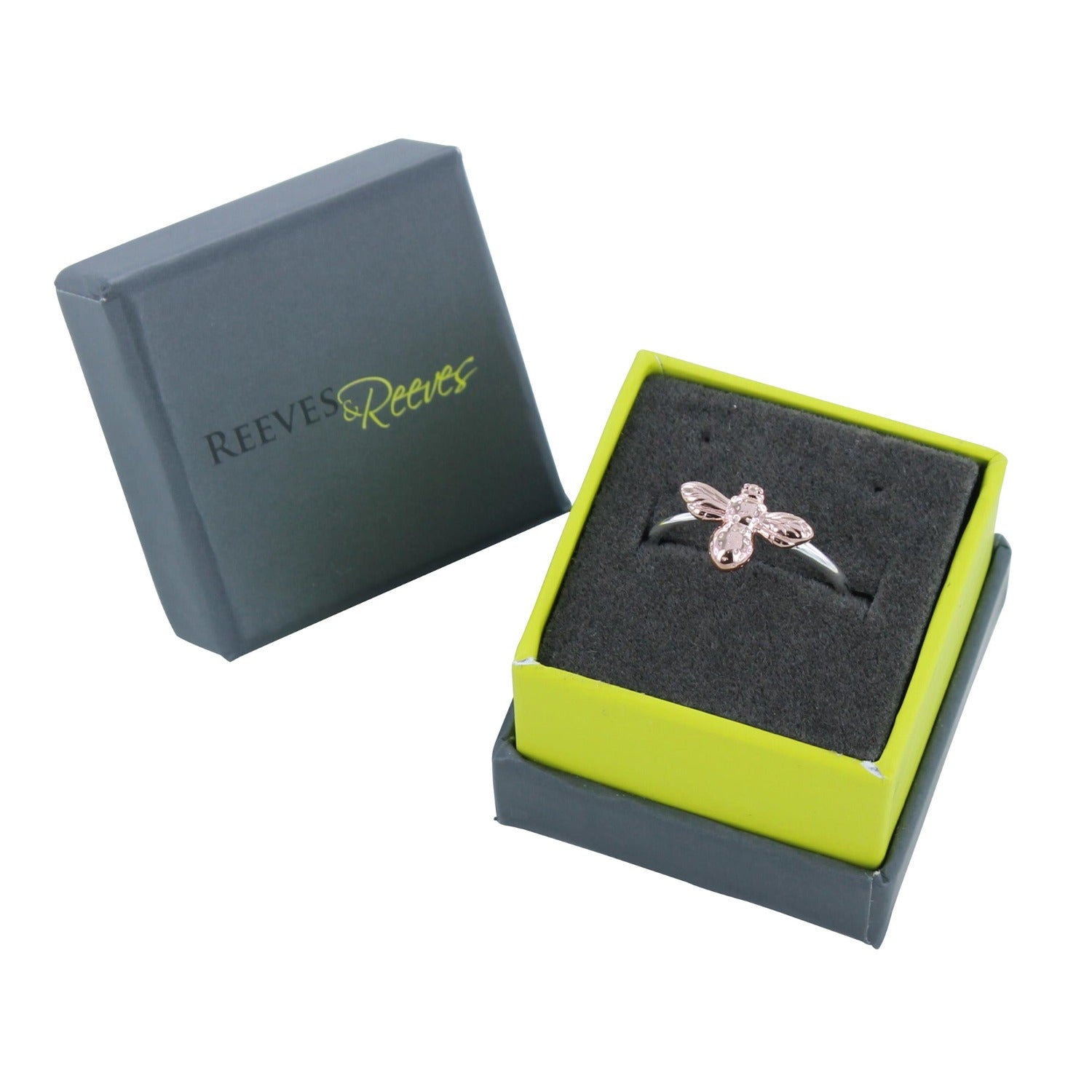 Silver banded adjustable ring with a rose gold bee as the central feature, shown in a Reeves & Reeves grey and green branded gift box.