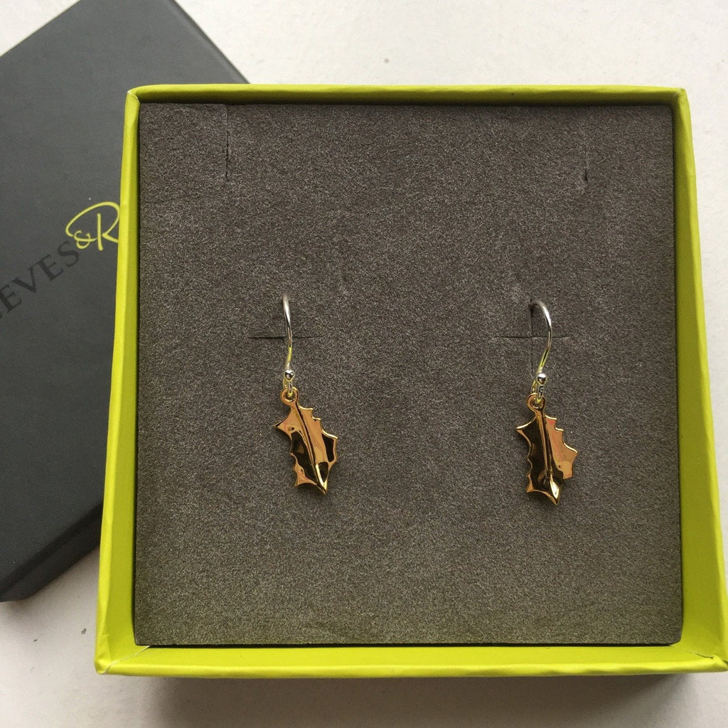A pair of Holly drop earrings in sterling silver with 18ct gold plating, hanging on silver hooks and shown in a Reeves & Reeves gift box.