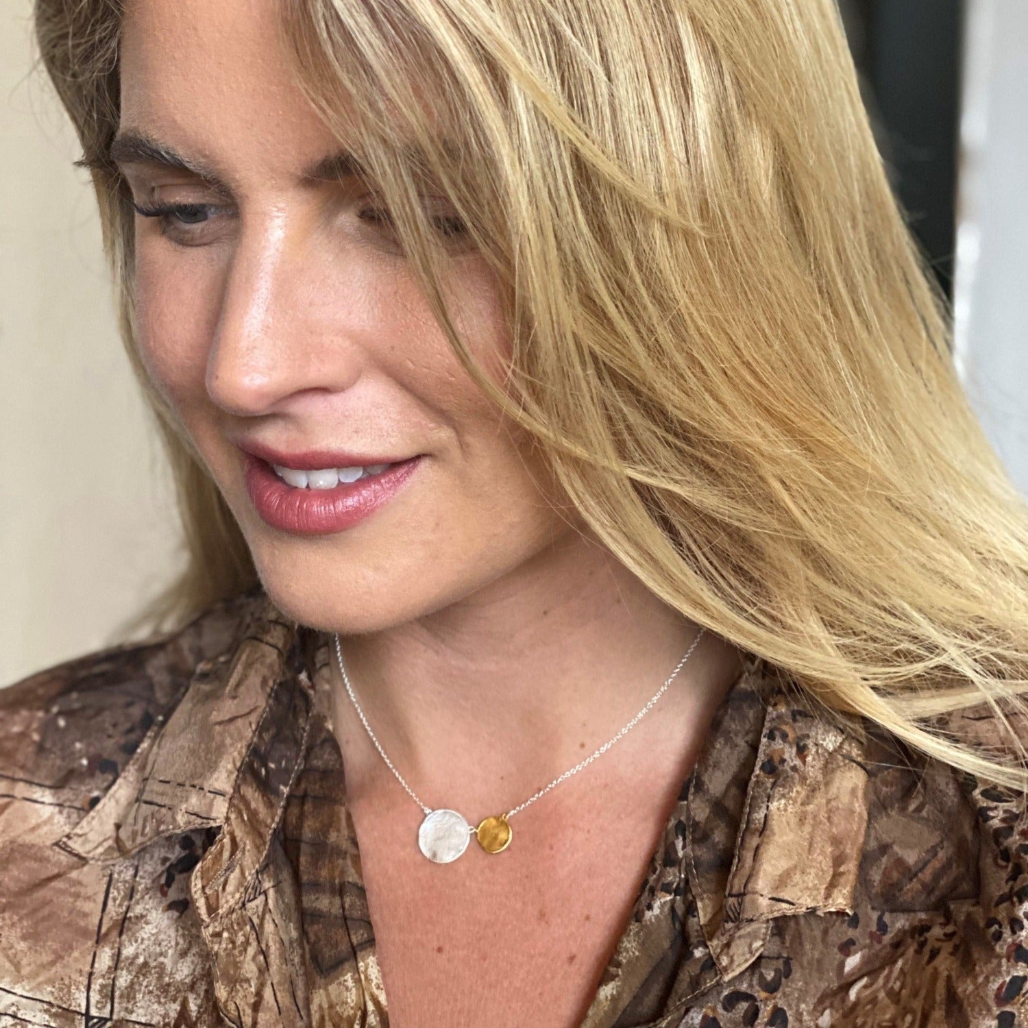 Sterling Silver and gold plate 'penny' necklace with two matt discs sat next to each other on a silver chain. Worn on a models neck.