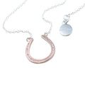 Sterling Silver and rose gold plate horseshoe necklace, sat centrally on a silver chain.