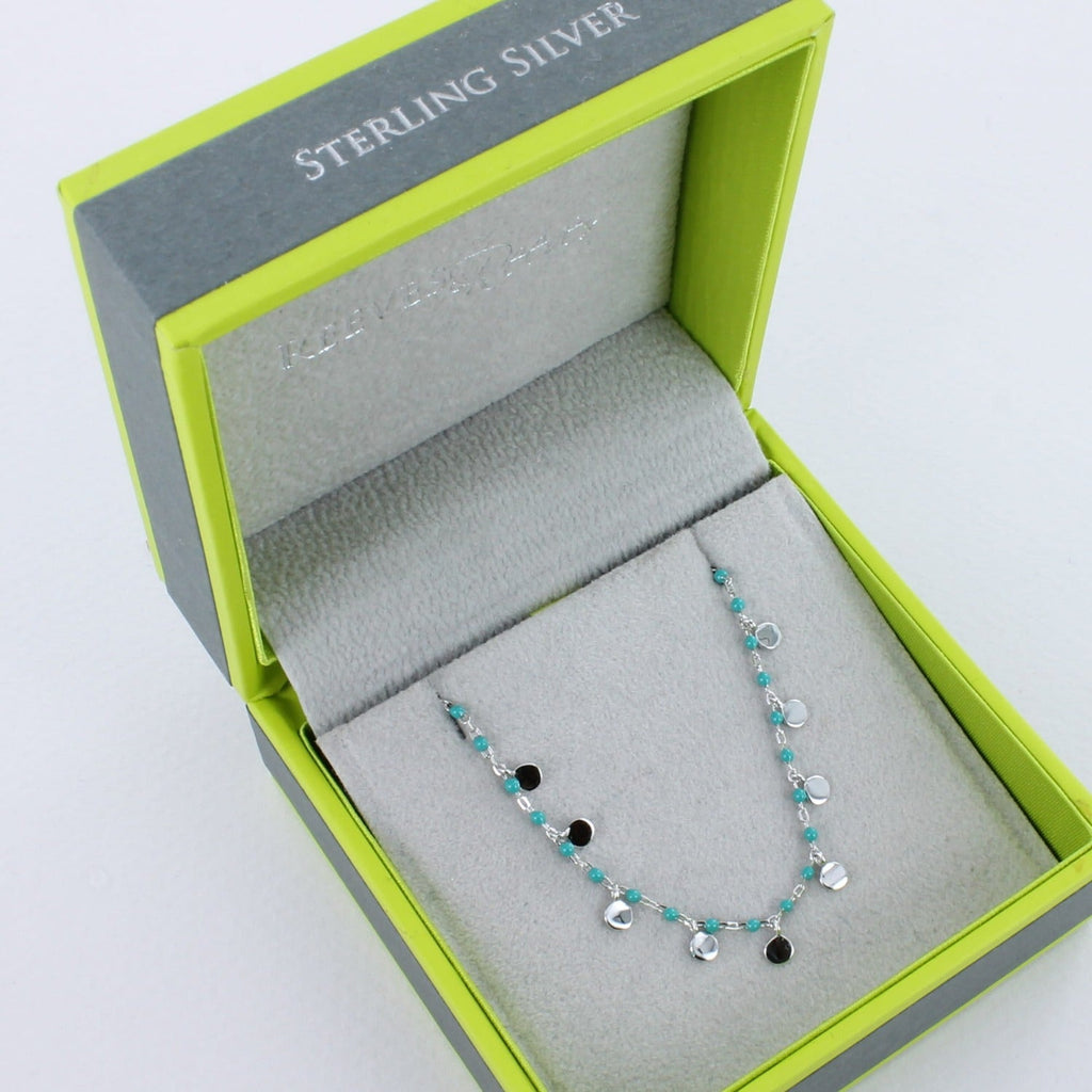 Silver and turquoise bead bracelet shown in a Reeves & Reeves grey and green branded gift box.
