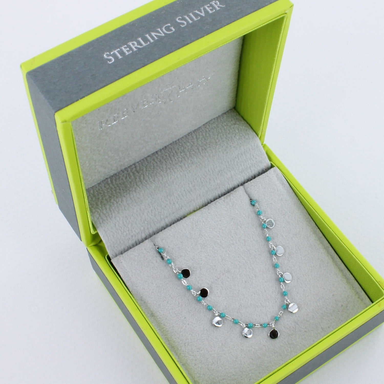 Silver and turquoise bead bracelet shown in a Reeves & Reeves grey and green branded gift box.