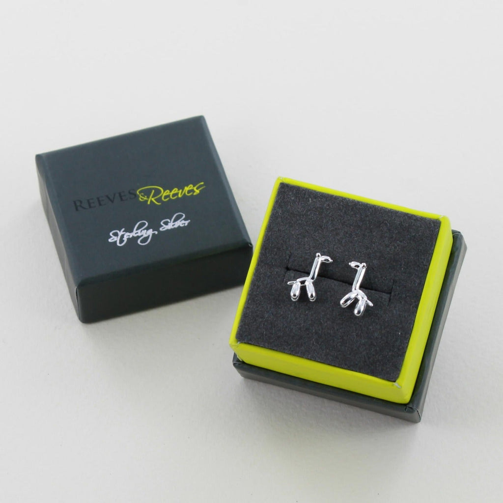 A pair of sterling silver balloon style giraffe stud earrings, shown in a Reeves & Reeves gift box.