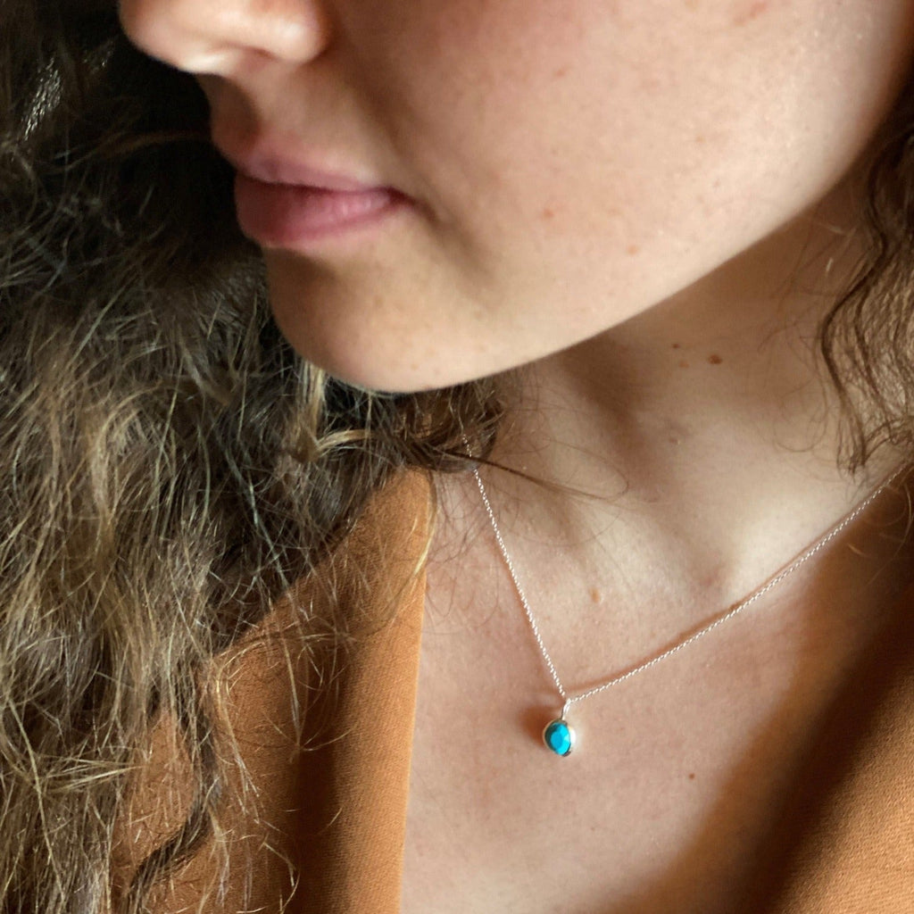 A turquoise december birthstone necklace worn on a model.