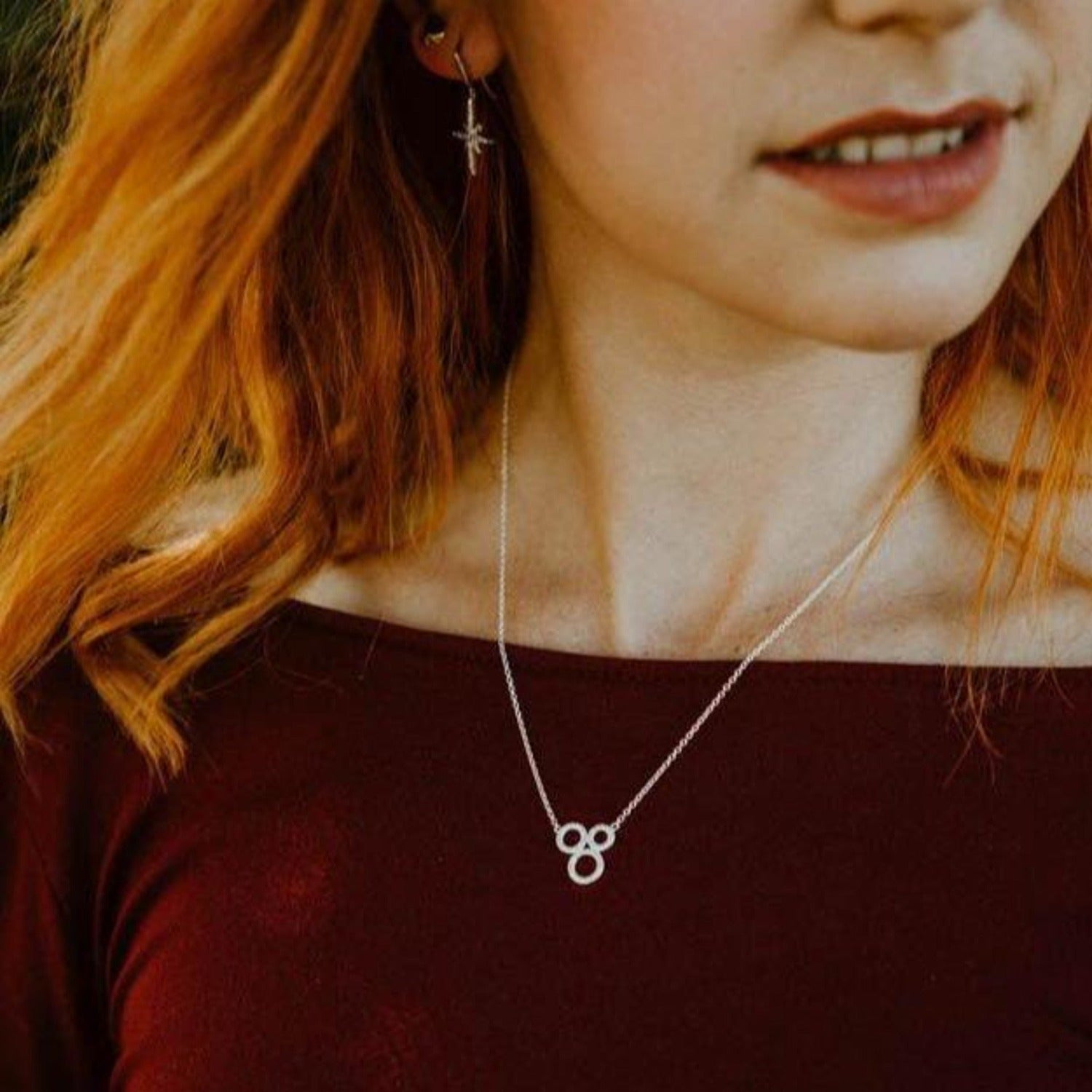 A sterling silver necklace comprising of three circular shapes filled with cubic zirconia stones and sat centrally on a fine silver chain.