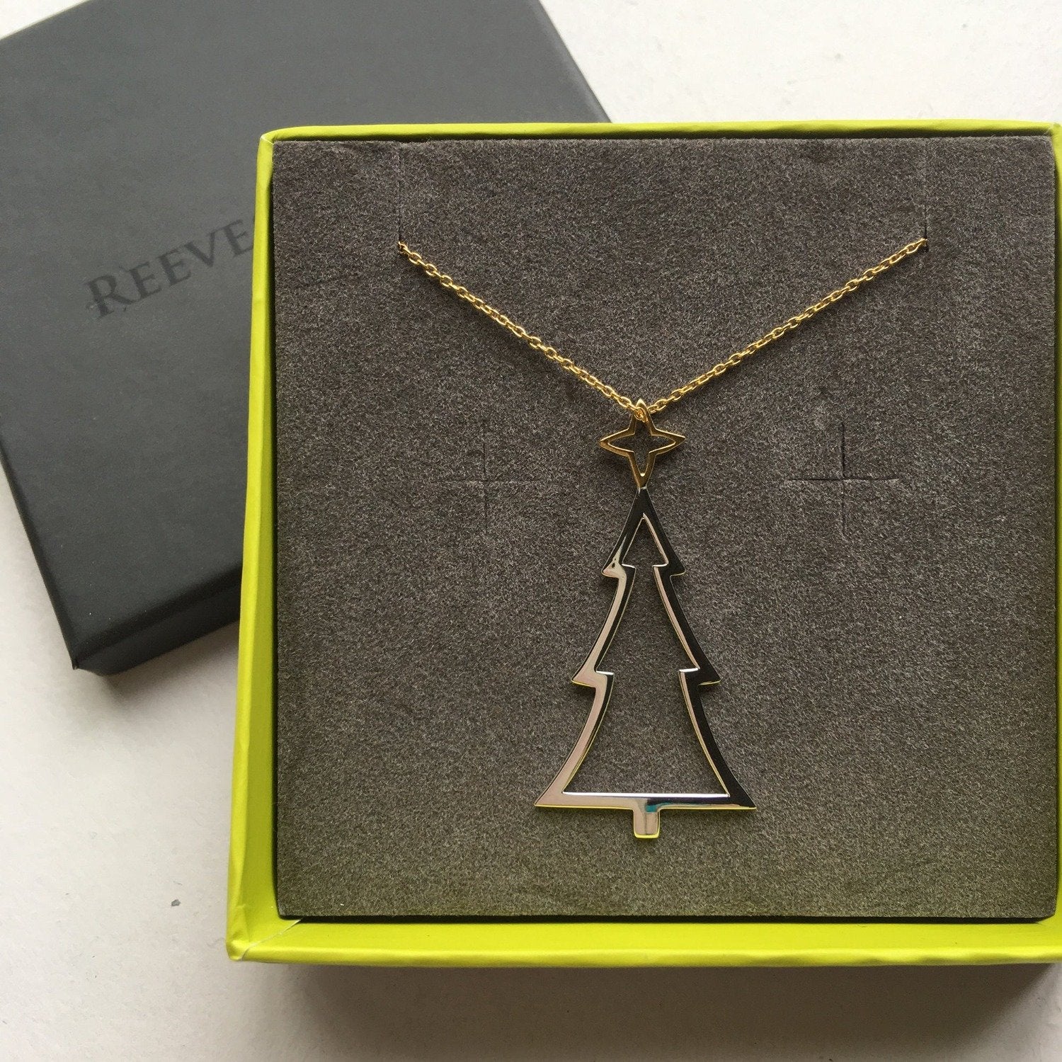 Sterling Silver Christmas Tree Pendant with a gold plated star on top, hung on a silver chain and shown in a Reeves & Reeves gift box.