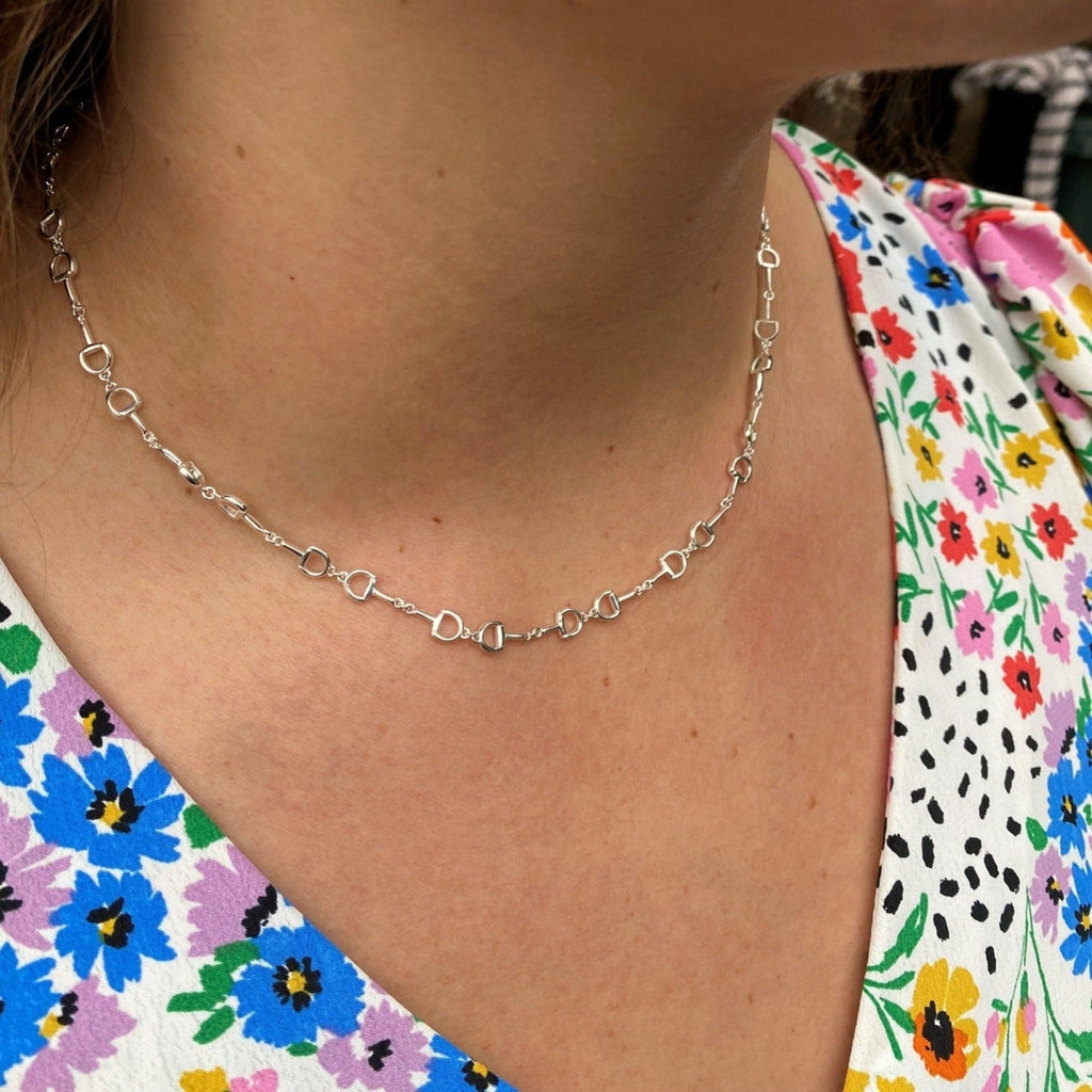 A Sterling Silver Continuous Snaffle Necklace worn on a models neck.
