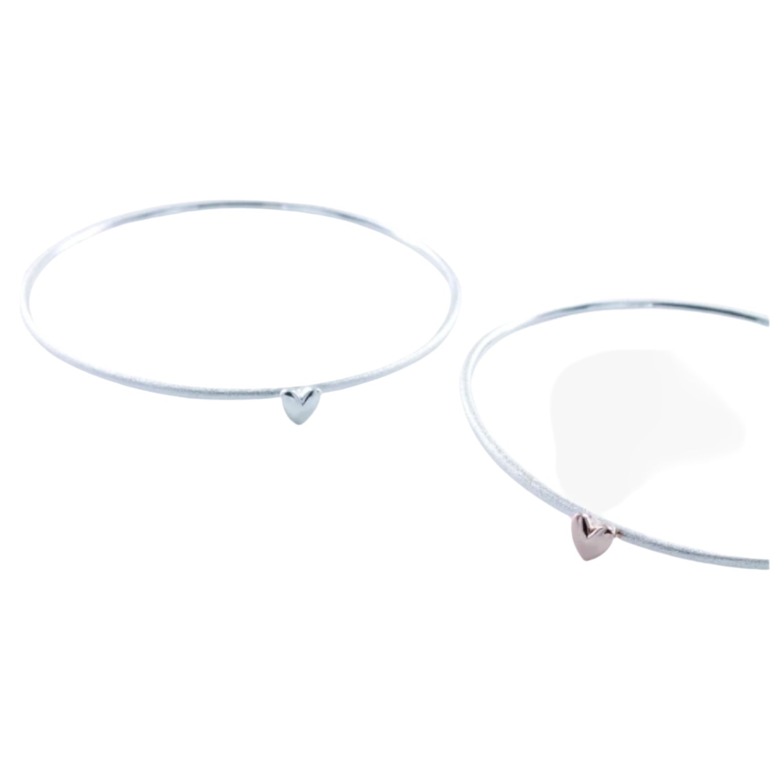 Two fine silver bangles, one with a silver heart and one one with a rose gold heart.
