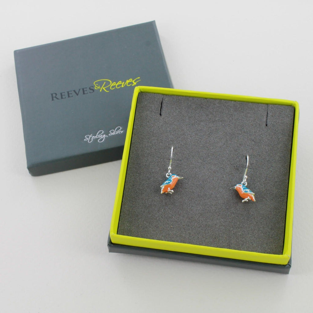 A pair of Kingfisher drop earrings, in sterling silver with blue and orange enamel detail, shown in a Reeves & Reeves gift box.