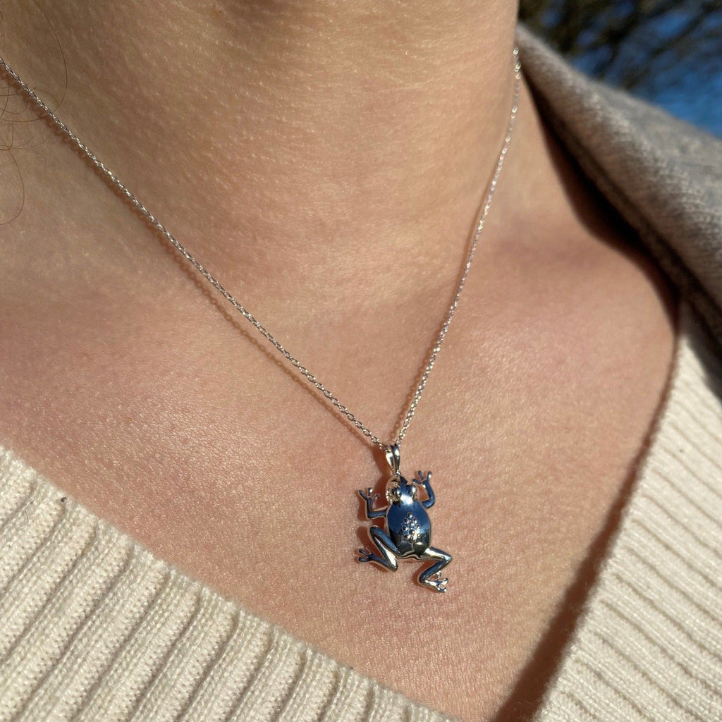 Sterling Silver Frog Pendant hanging on a silver adjustable chain and worn on a model.