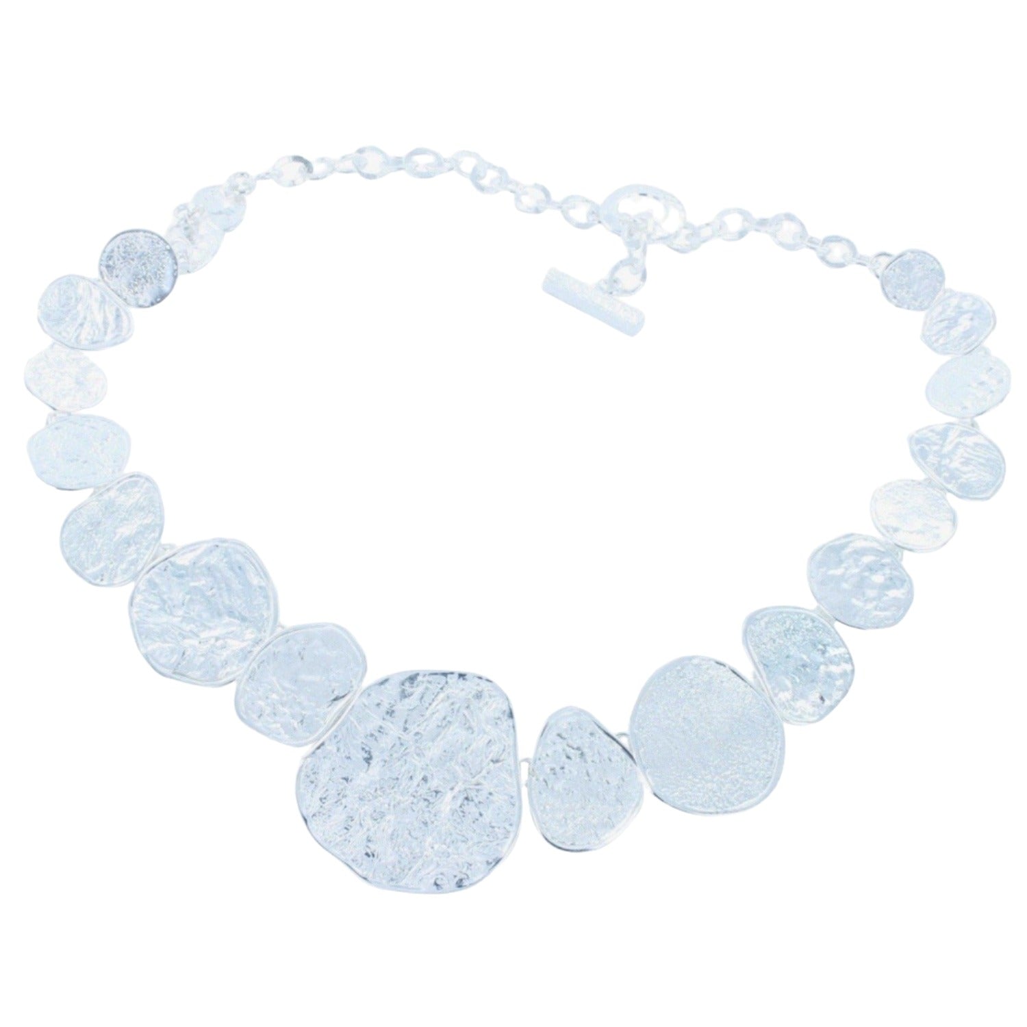 A sterling silver necklace with varying circular irregular shapes with a textured finish, finished with a t bar clasp.