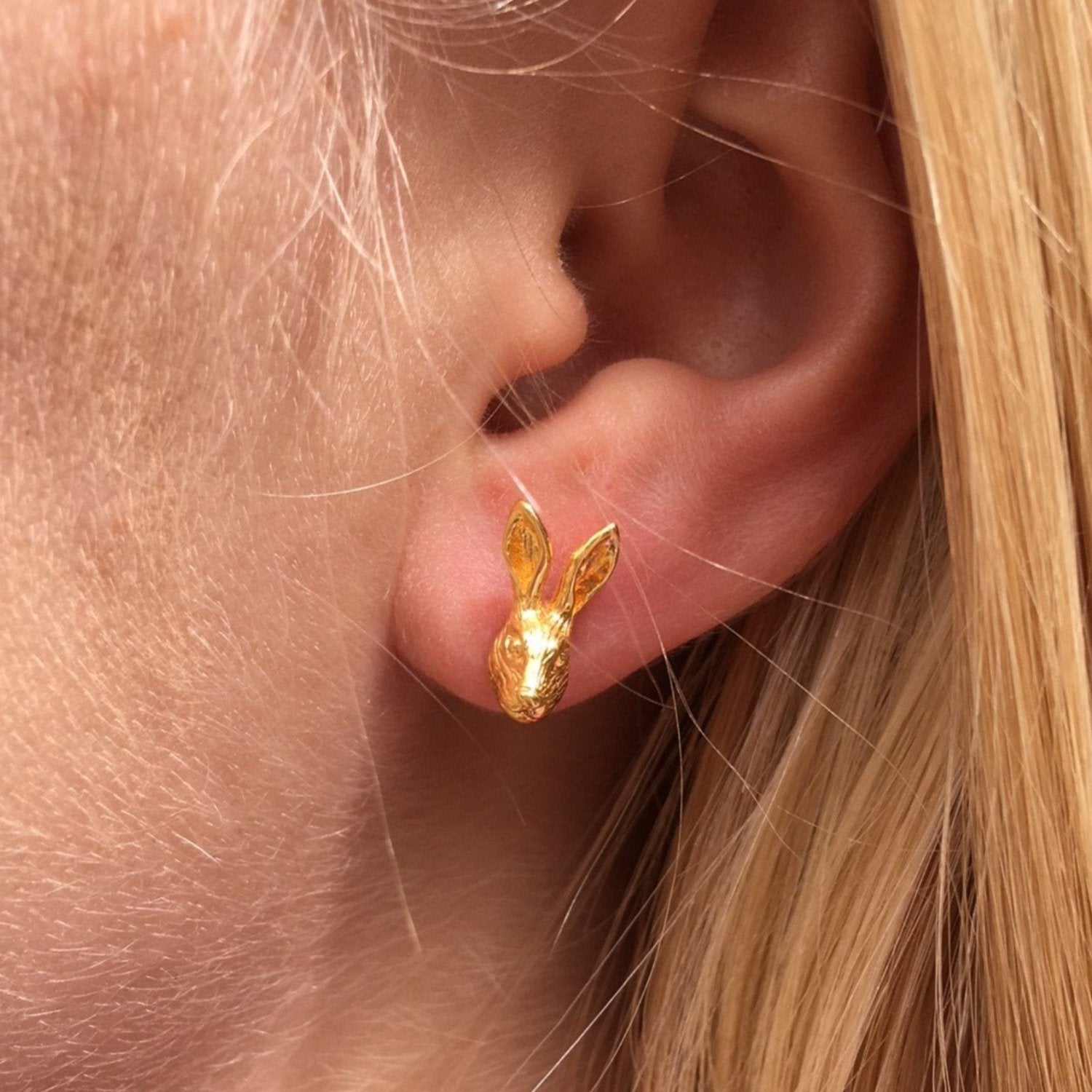 A pair of sterling silver Hare Stud Earrings with silver and 18ct gold plate, worn in a ladies ear.