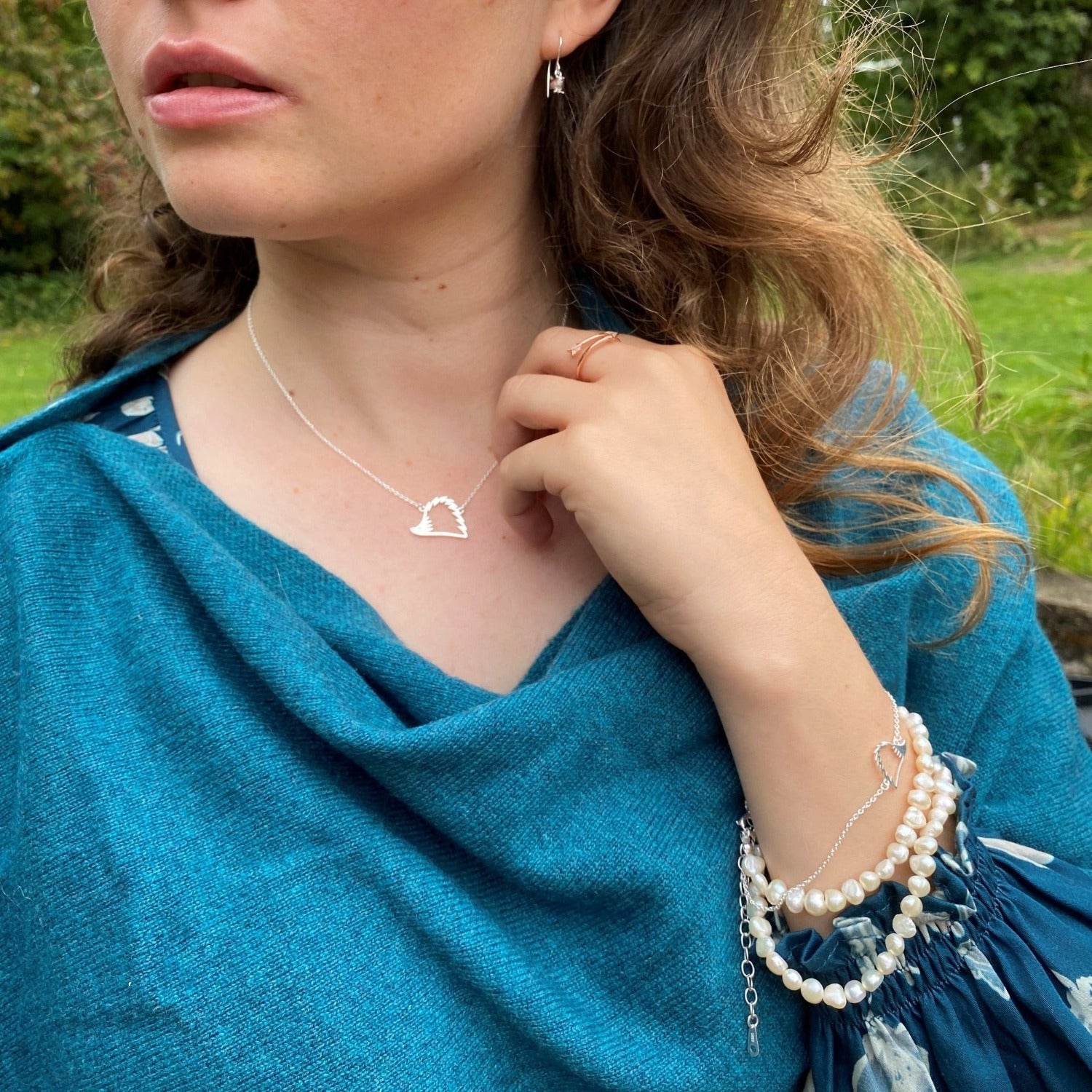 A sterling silver Hedgehog Silhouette Necklace, hung centrally on a silver adjustable chain and worn on a model.