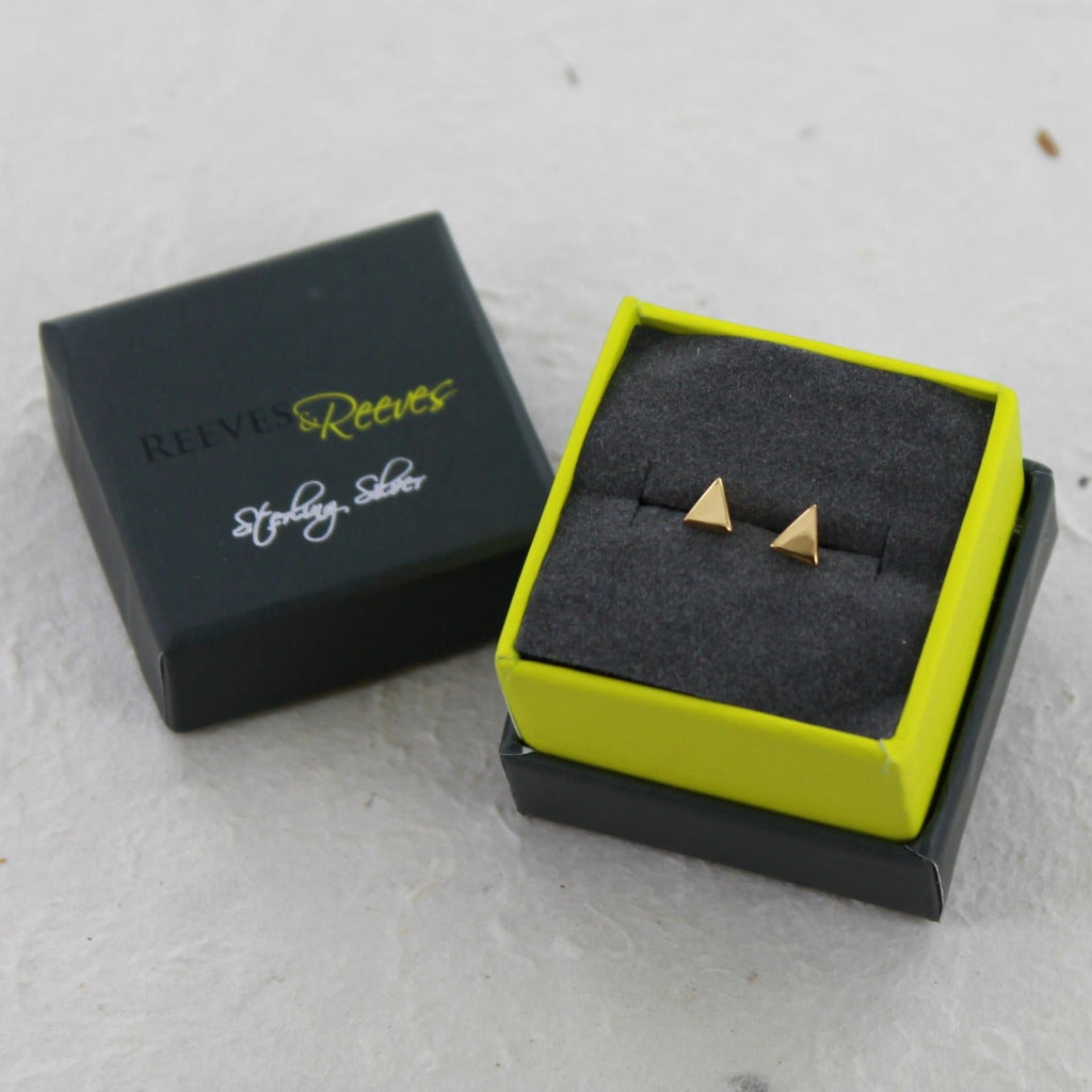 A pair of sterling silver triangle stud earrings, shown in a Reeves & Reeves gift box.