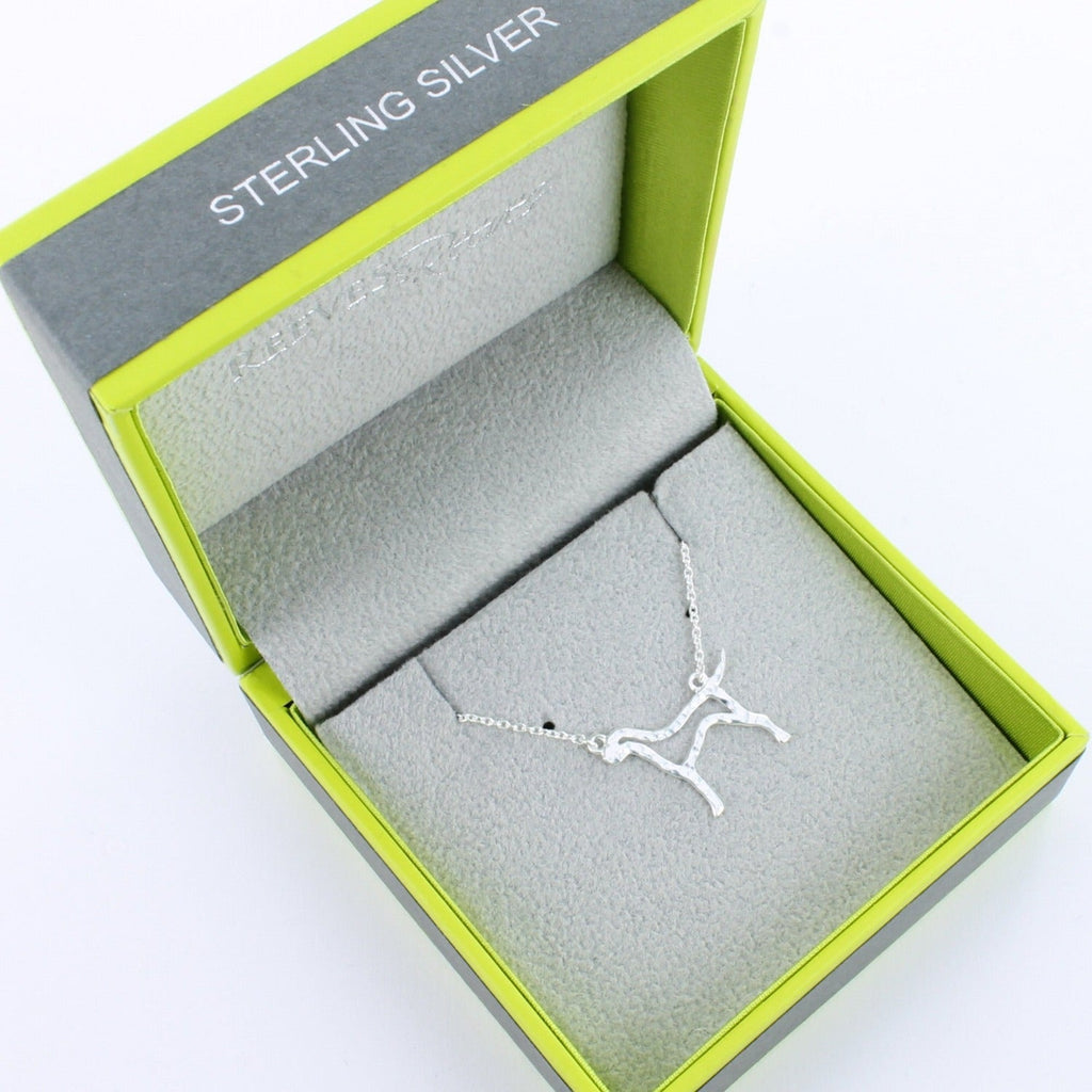 A sterling silver Hound Silhouette with a hammered finish, hung centrally on a silver chain and shown in a Reeves & Reeves grey and green gift box.