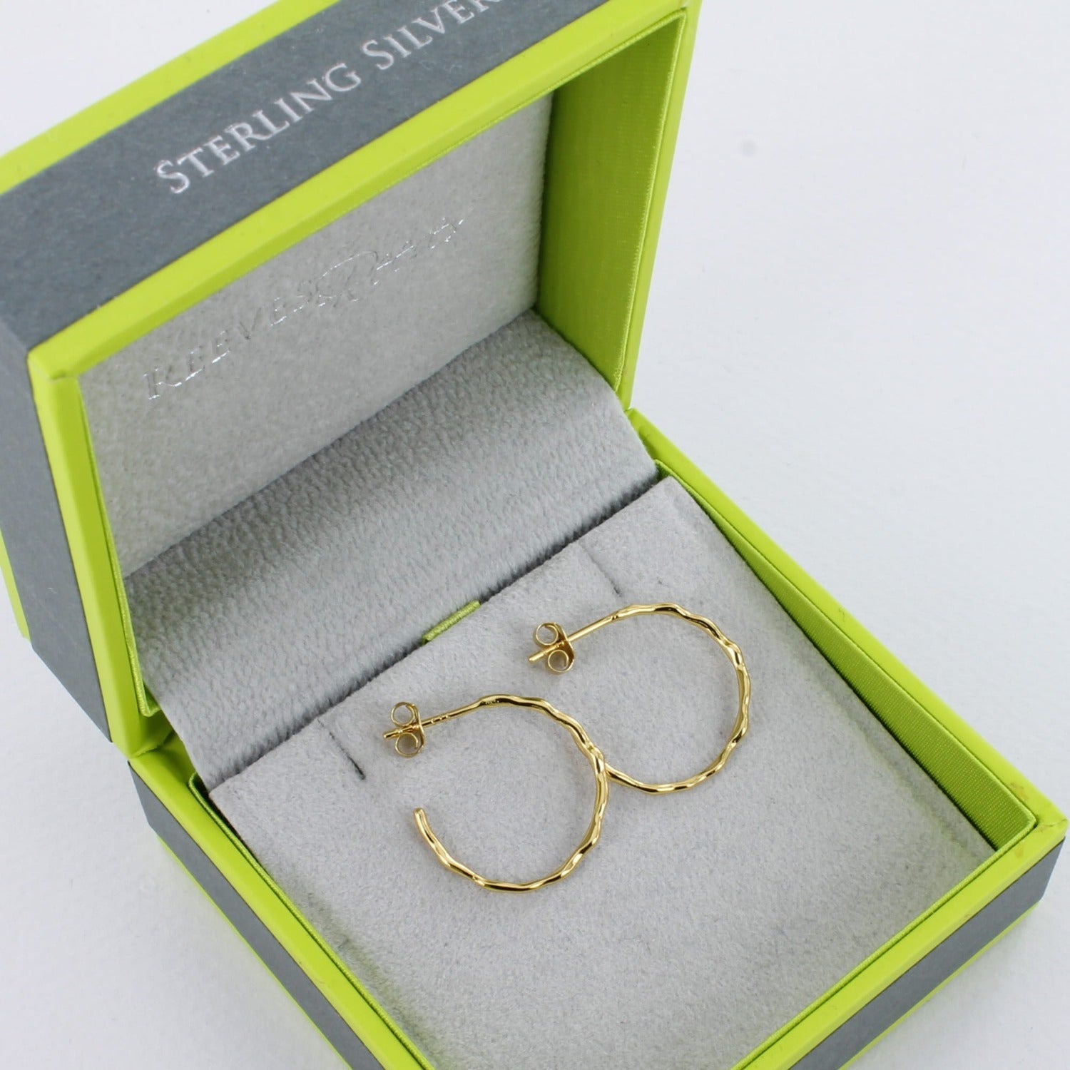 A pair of sterling silver hula hoop earrings, with 18ct gold plate and a slightly textured finish. Shown in a Reeves & Reeves grey and green gift box.