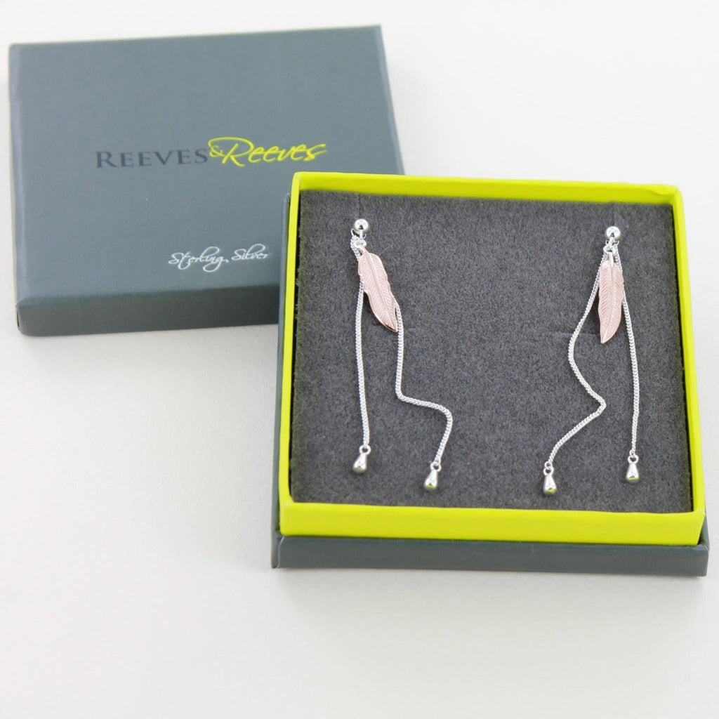  A pair of sterling silver leaf drop earrings hanging from a stud style post and two fine chains hanging behind.