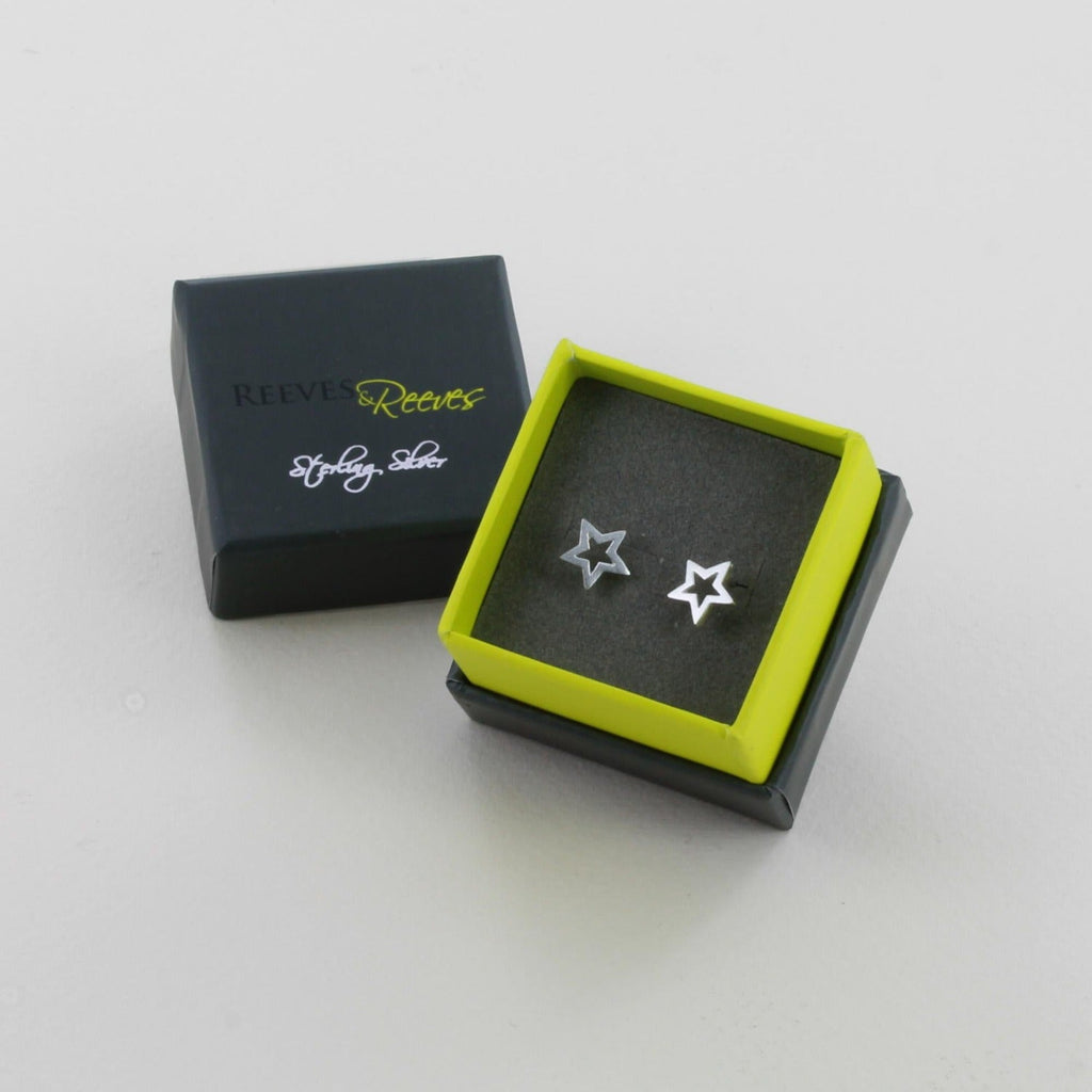 A sterling silver star silhouette stud earring, shown in a Reeves & Reeves gift box.