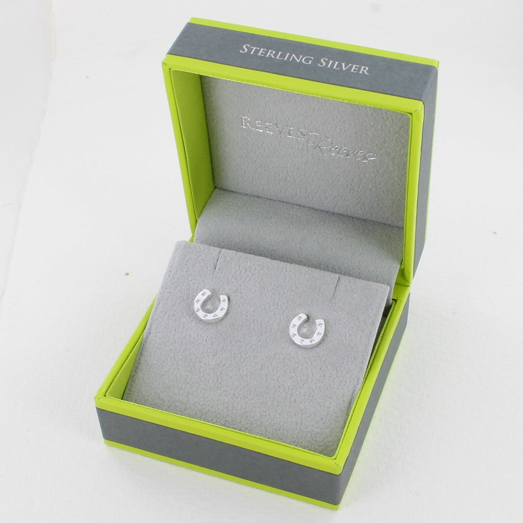 A pair of sterling silver horseshoe stud earrings, with cubic zirconia stones and shown in a Reeves & Reeves gift box.