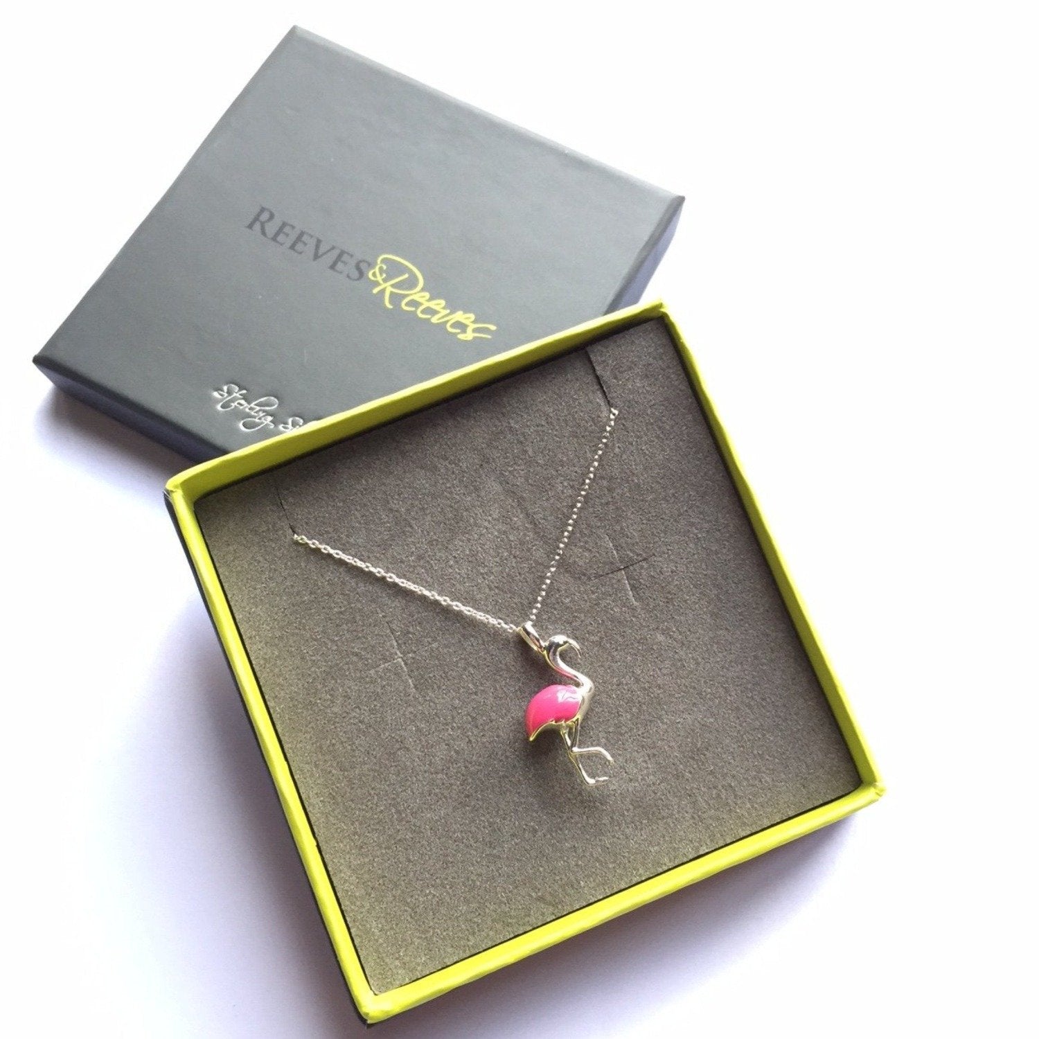 Sterling Silver Flamingo Pendant with hot pink enamel detail and hung on a silver adjustable chain. Shown in a Reeves & Reeves grey and green branded gift box.