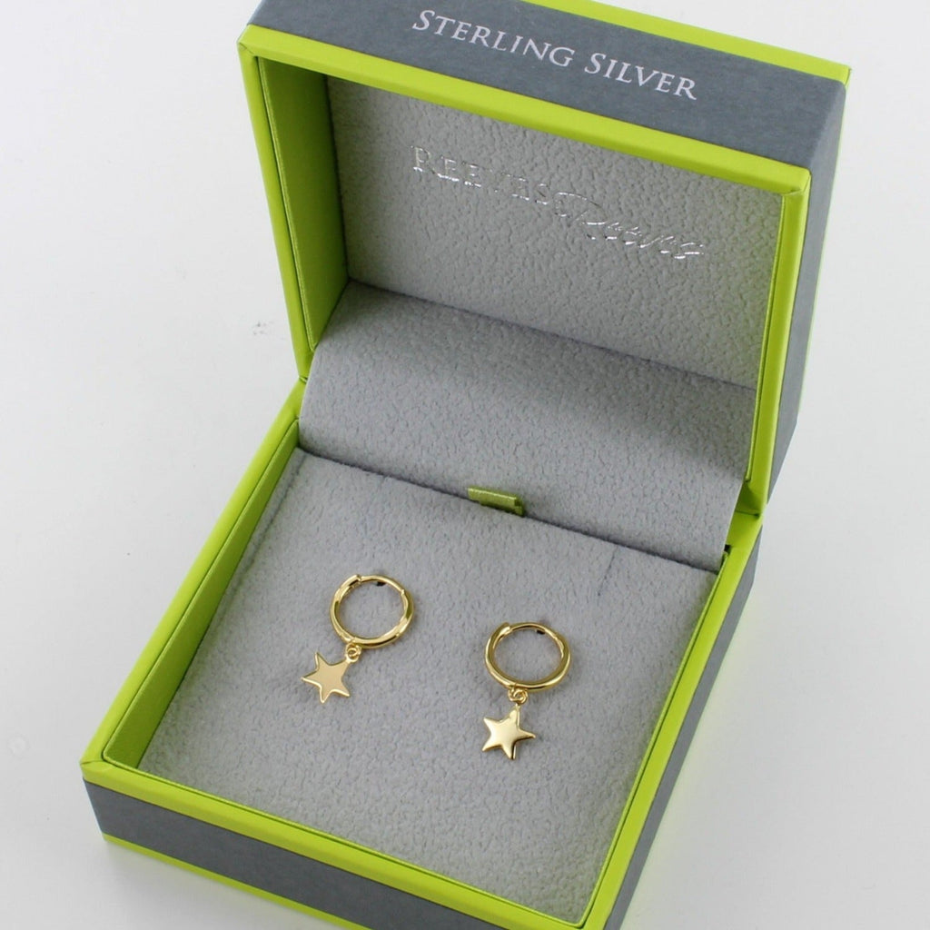 A sterling silver pair of hoop earrings with 18ct gold plating and star charms hanging from each hoop. Shown in a Reeves & Reeves grey and green gift box.