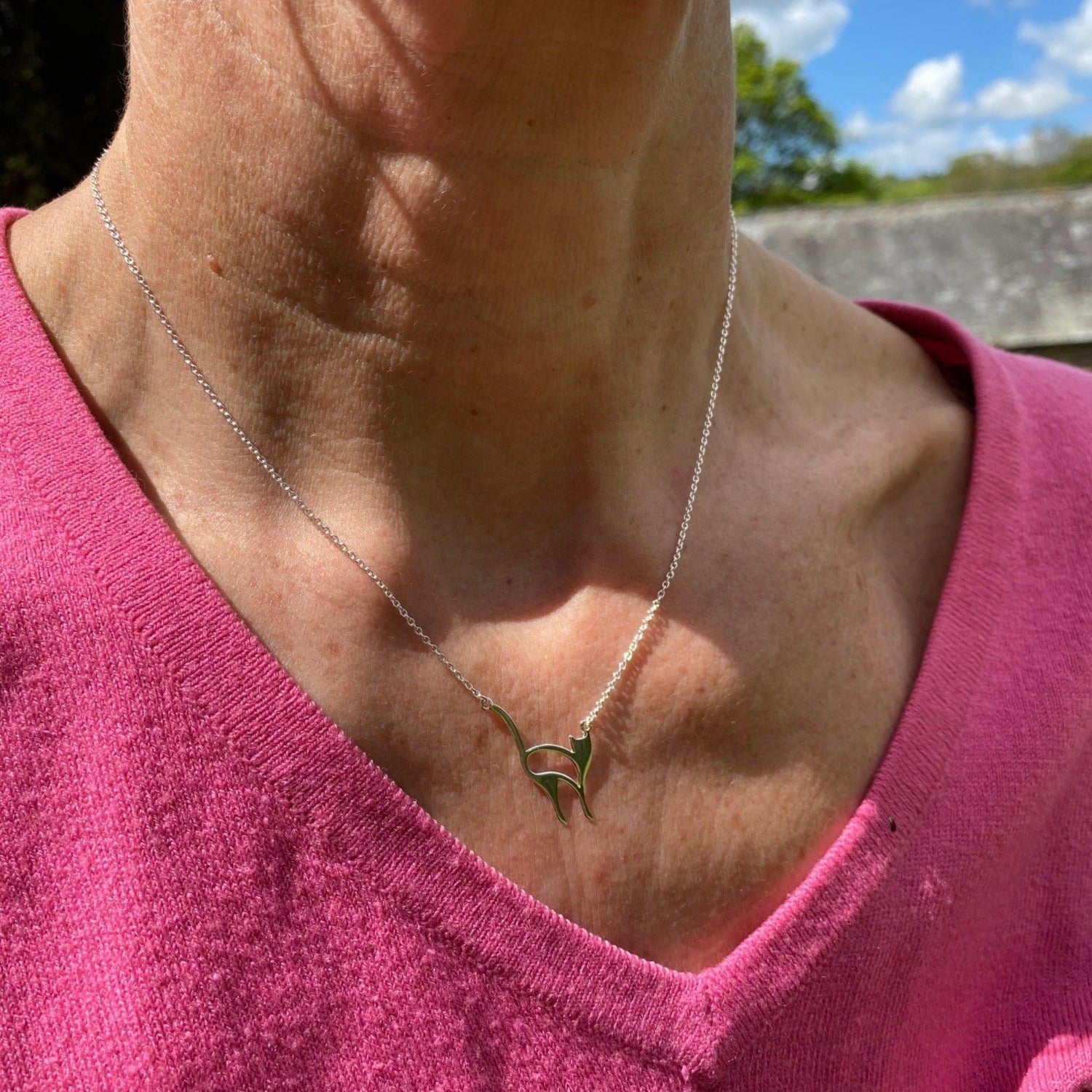 A sterling silver snooty cat necklace, in a flat silhouette style and hung centrally on a fine silver chain.