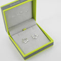 A pair of sterling silver star shaped huggie earrings, shown in a Reeves & Reeves gift box.