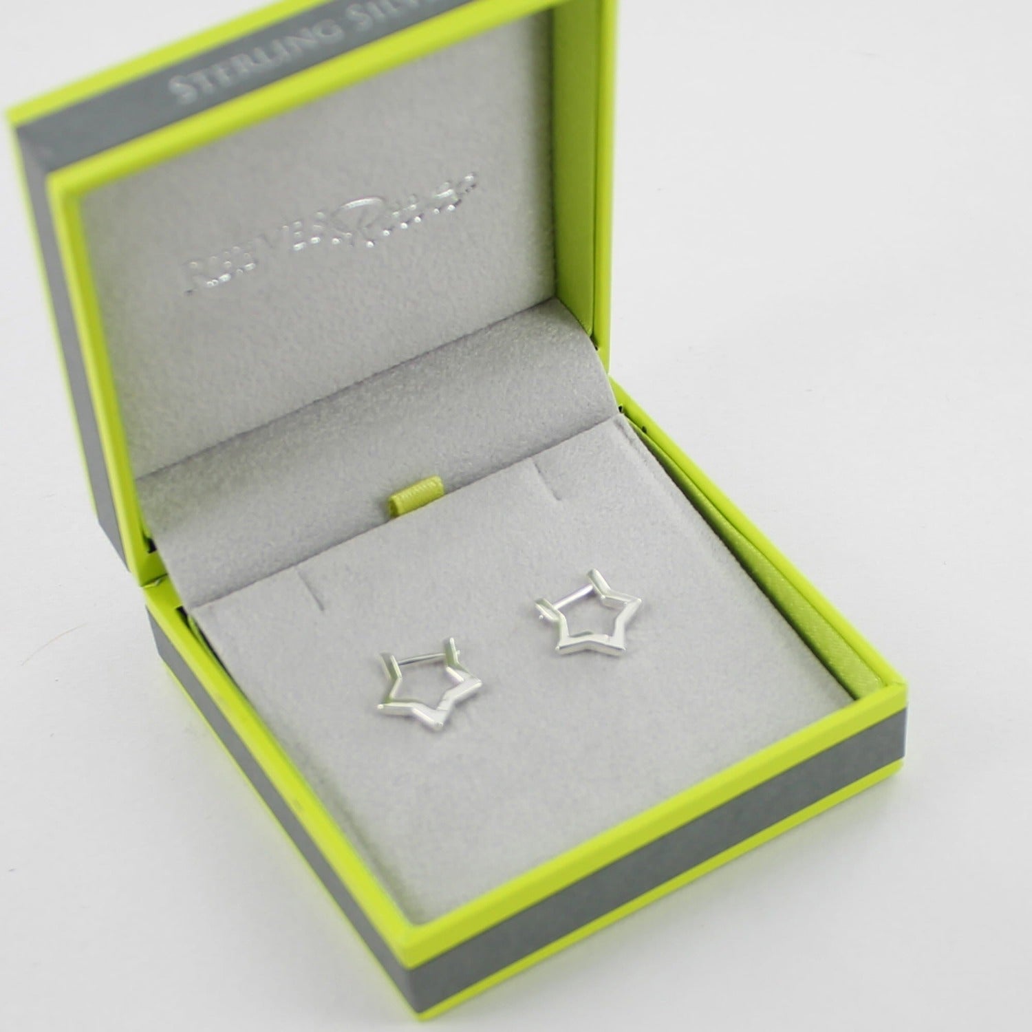 A pair of sterling silver star shaped huggie earrings, shown in a Reeves & Reeves gift box.