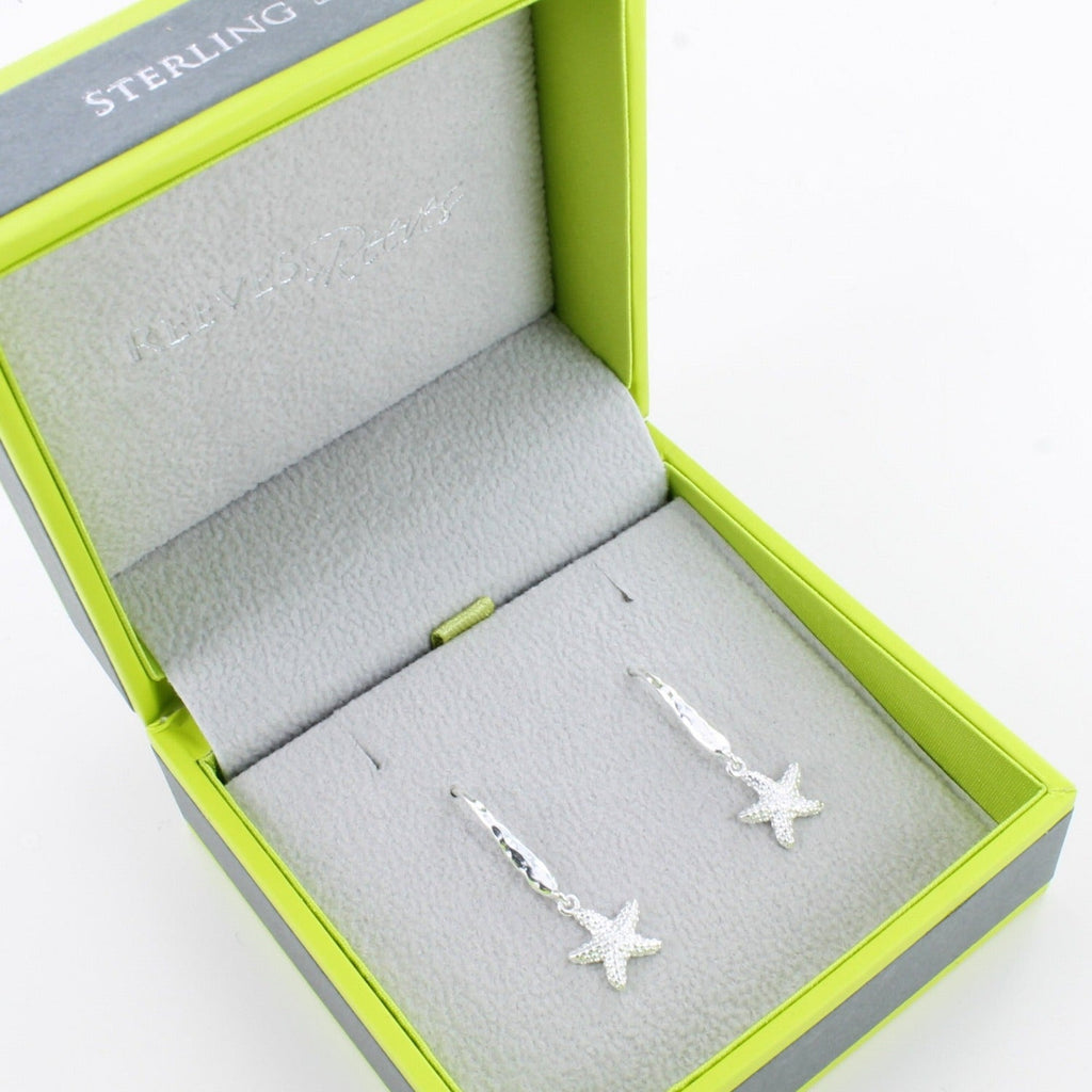 A pair of sterling silver starfish textured drop earrings with hammered hooks. Shown in a Reeves & Reeves grey and green gift box.